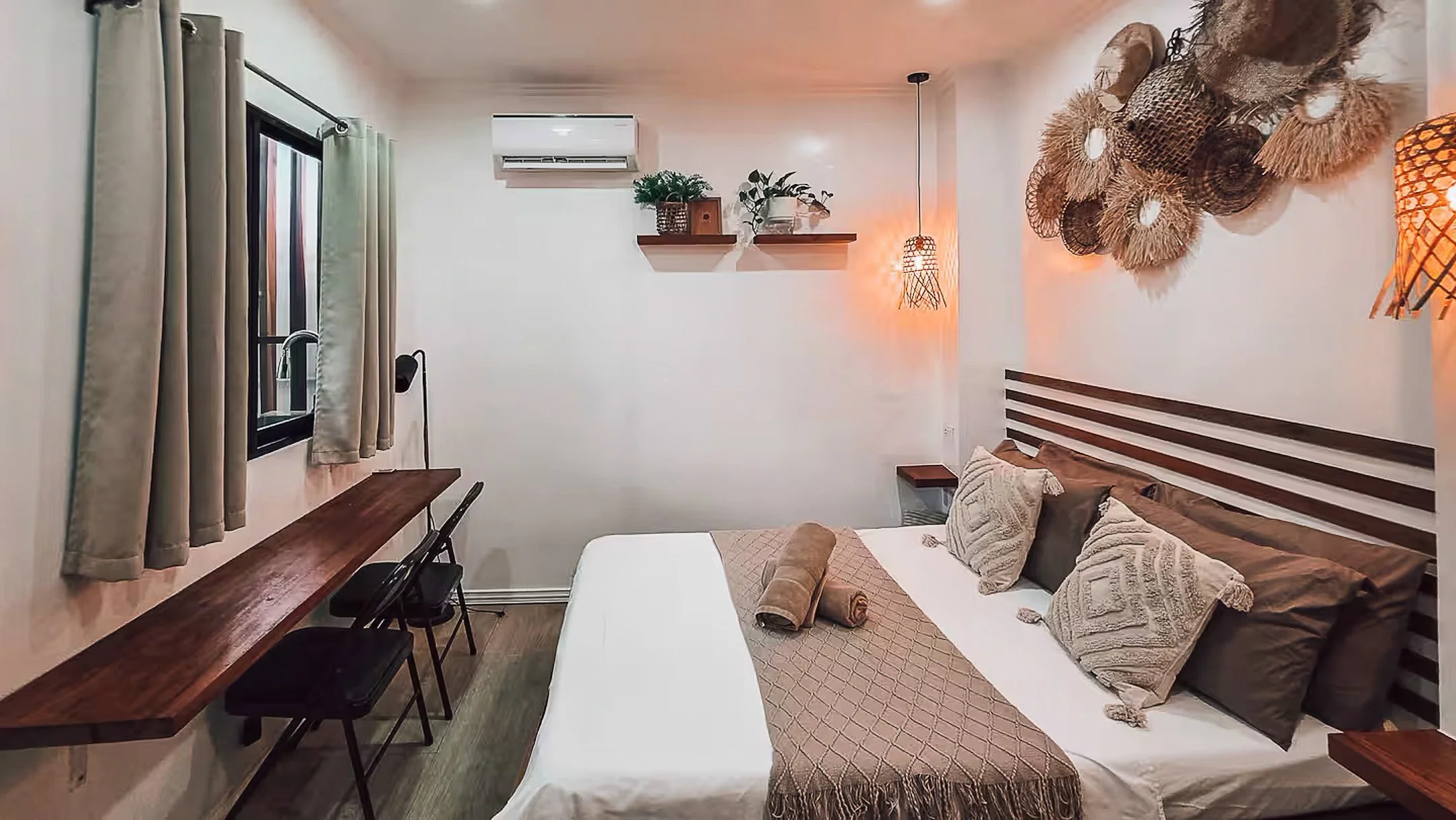 Surf & Chill Room 3 in Siargao offers a cozy retreat with a double bed, built-in work desk, and soft lighting that creates a calm, inviting space for rest or remote work after a day of exploring the island.