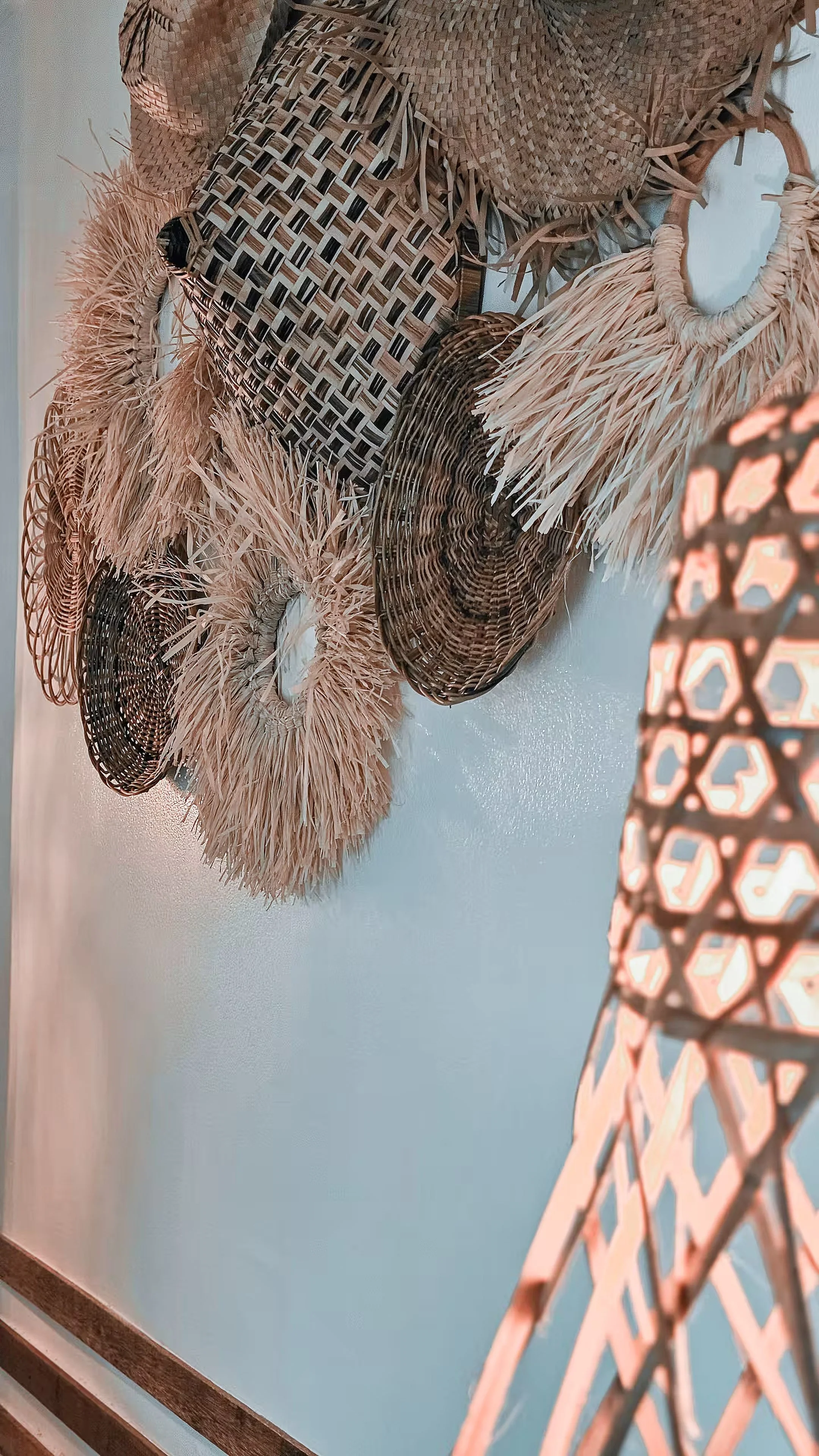 A close-up of handcrafted rattan wall pieces inside Surf & Chill Room 3, adding a touch of coastal warmth and local texture to the minimalist interior.