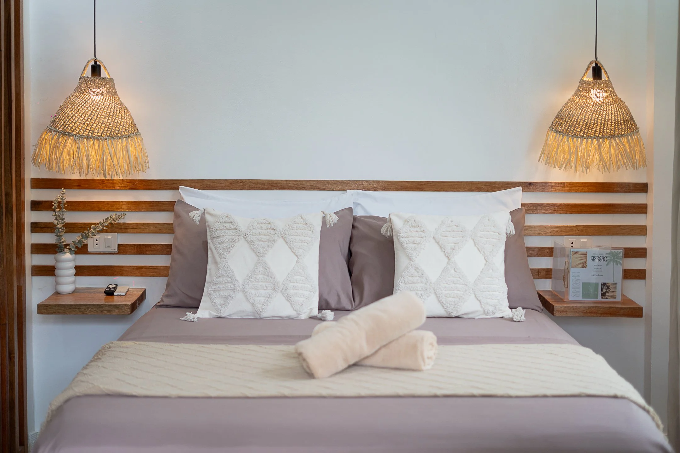 White Palm Villas Siargao bedroom with double bed, woven lamps, and warm minimalist tropical interior in a private villa