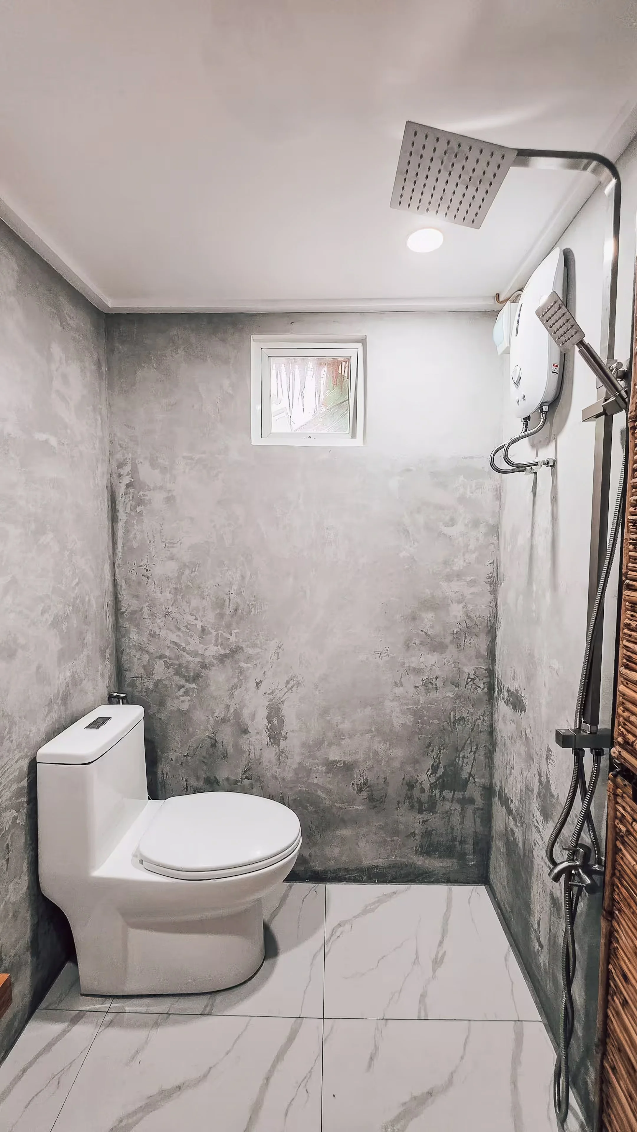 Private bathroom with toilet and rainfall shower inside Surf and Chill Room 3 in Siargao.