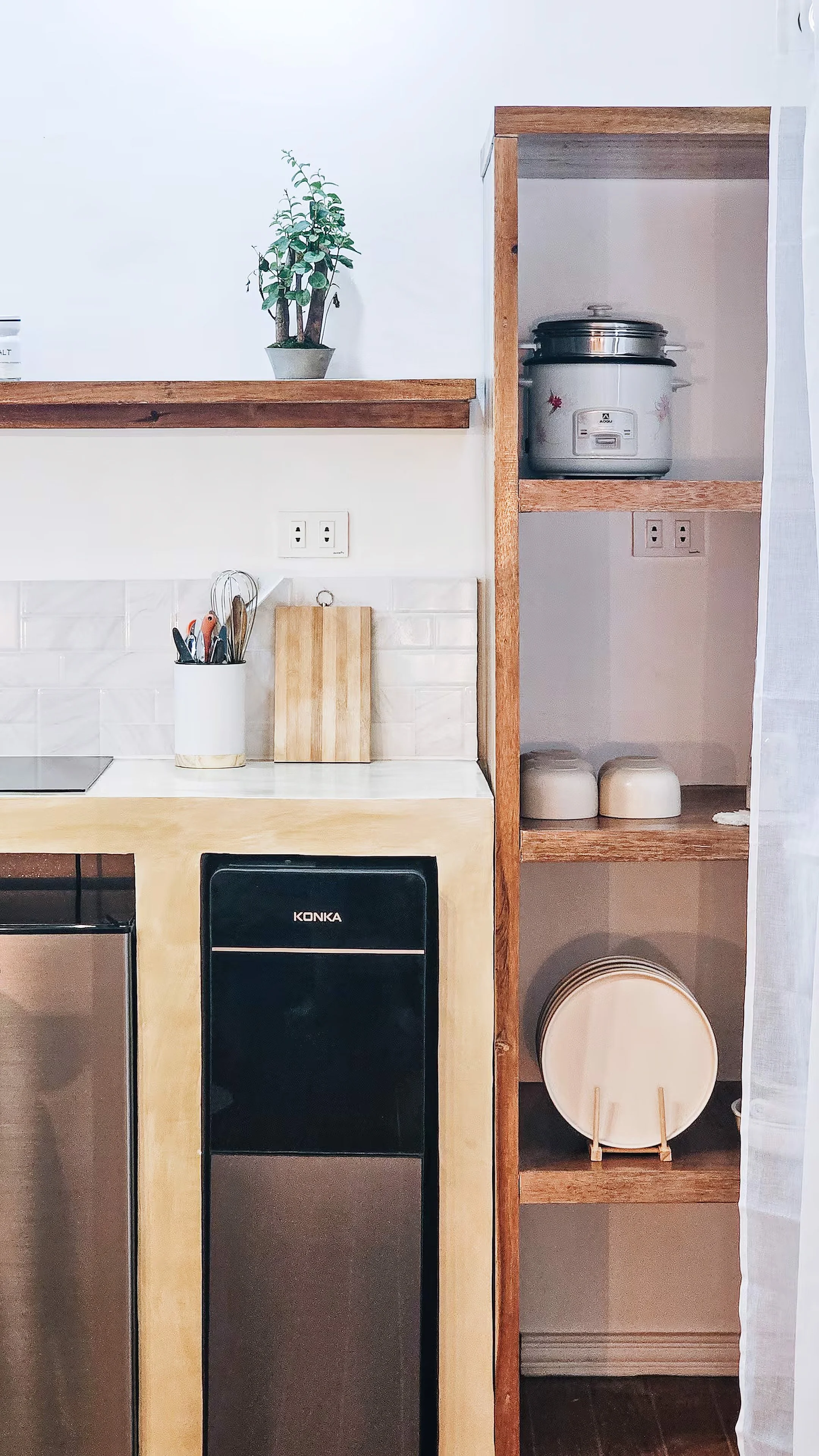 Compact kitchenette in Room 1 at Surf & Chill Siargao featuring a mini fridge, rice cooker, and open wooden shelves.