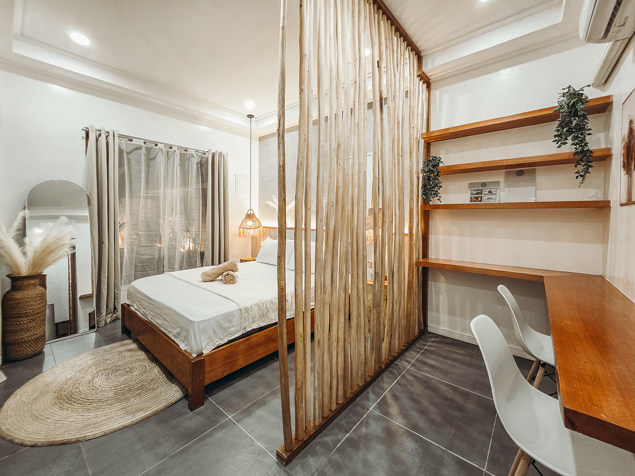 White Palm Villas Siargao bedroom with wooden partition, workspace desk, and minimalist tropical interior in a private villa