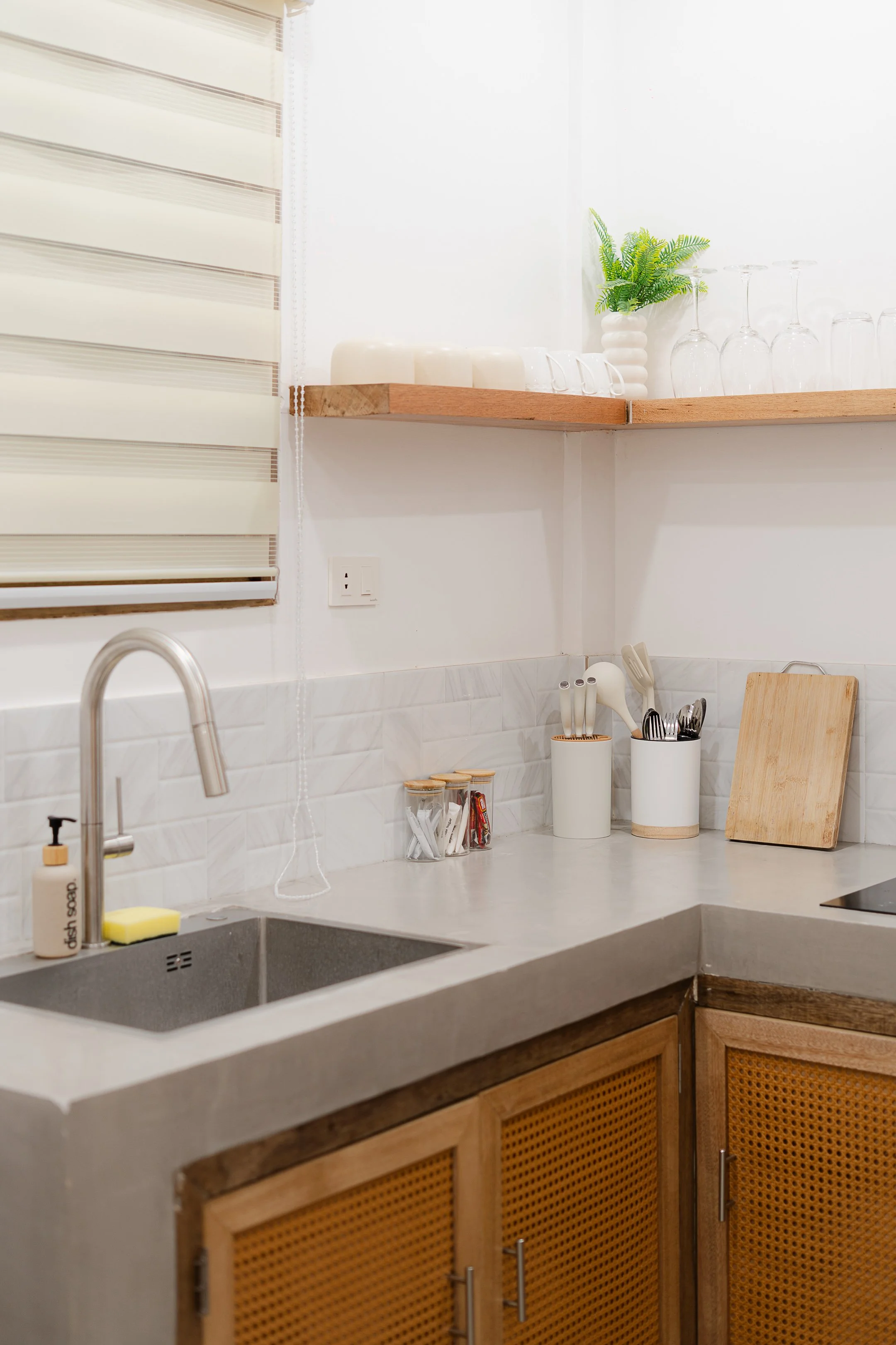 White Palm Villas Siargao kitchenette with concrete sink, wooden cabinets, and minimalist tropical interior with open shelving