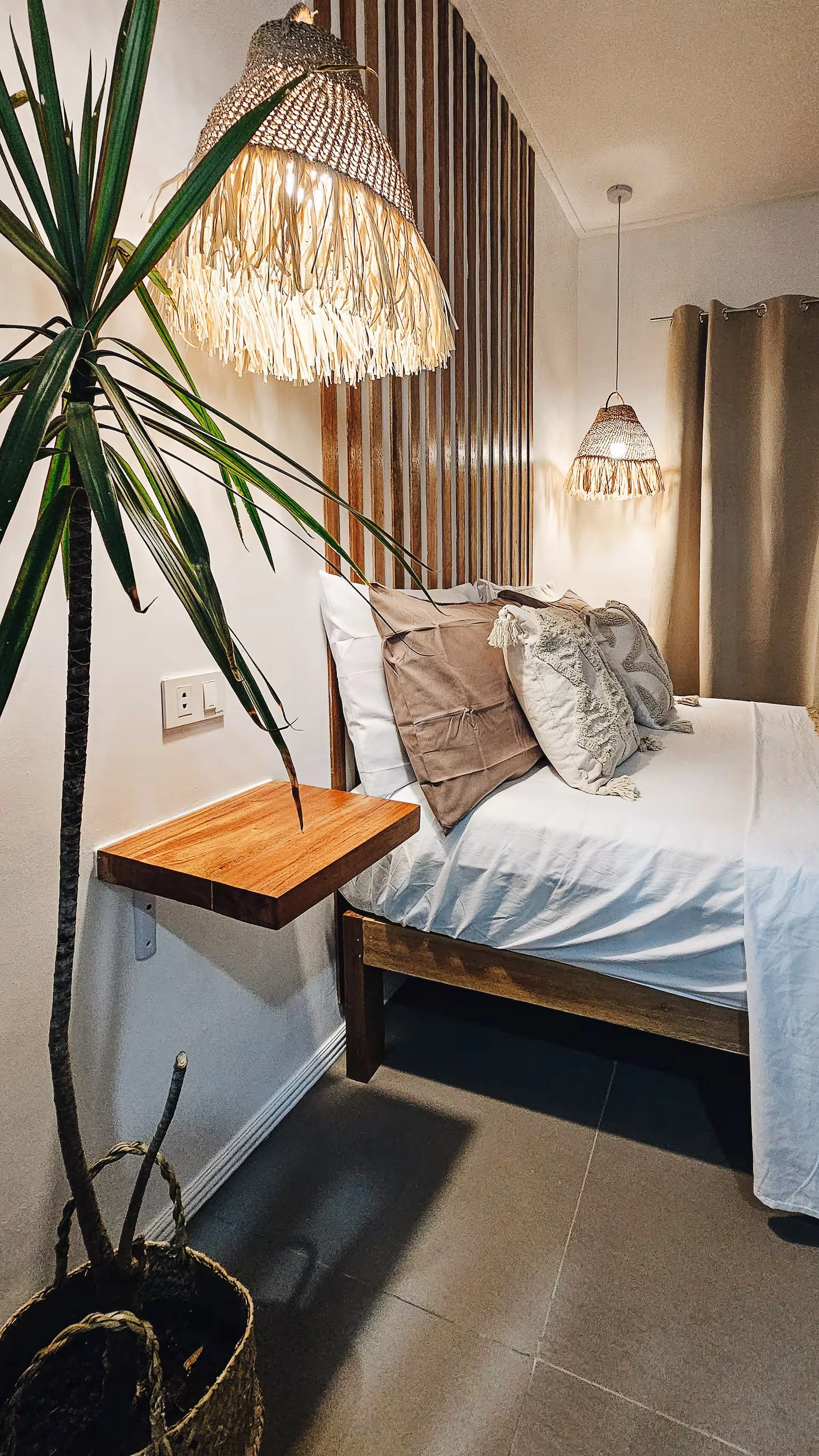 Earthy tones and soft lighting set a calm mood in Room 2. Woven lamps and natural textures create a cozy retreat after a day exploring Siargao.