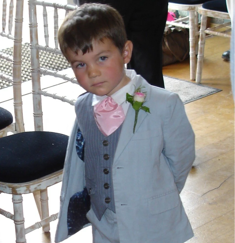 Small boy in a suit in a sunny event room