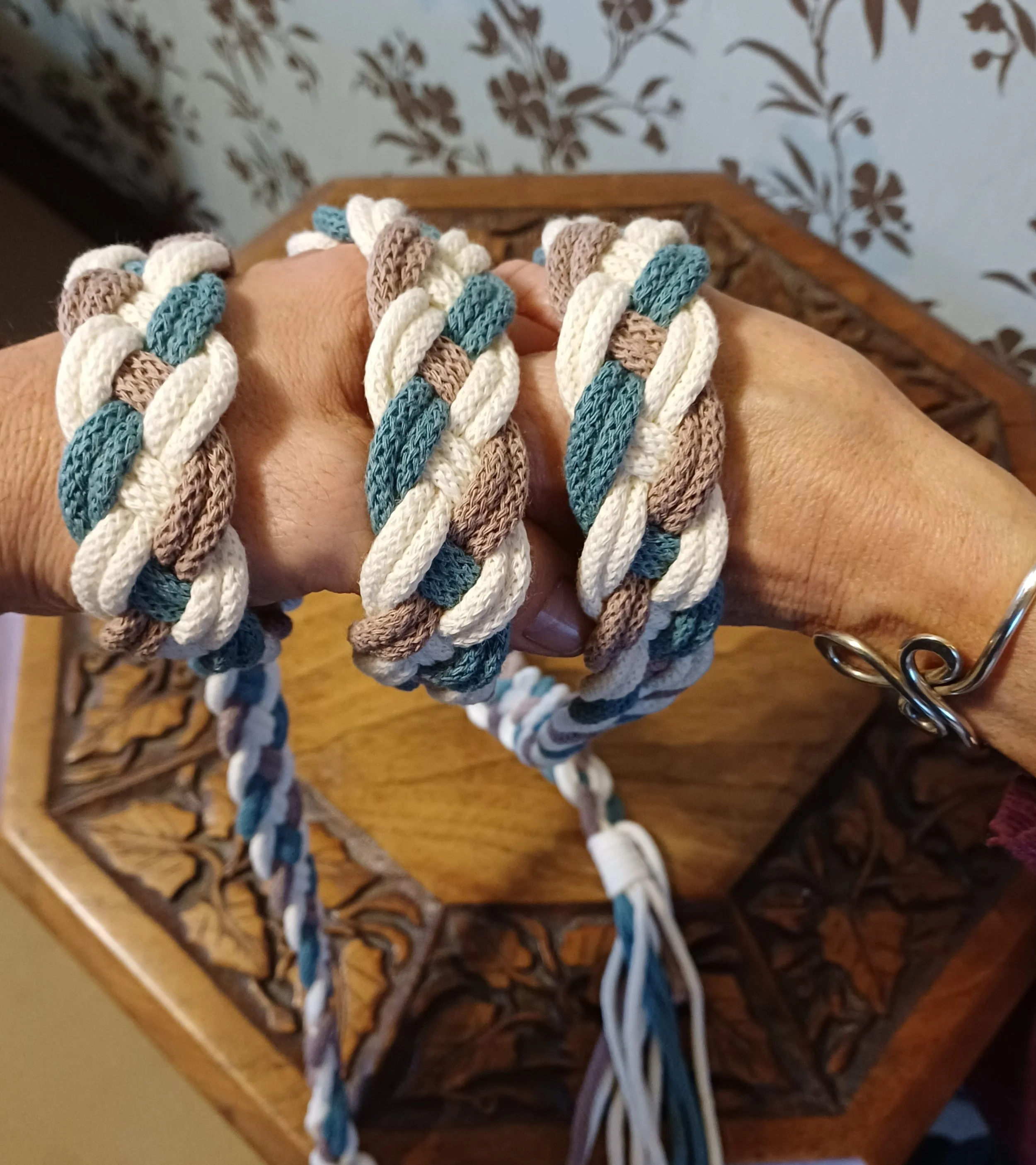 Hands with blue white and brown handfasting cord