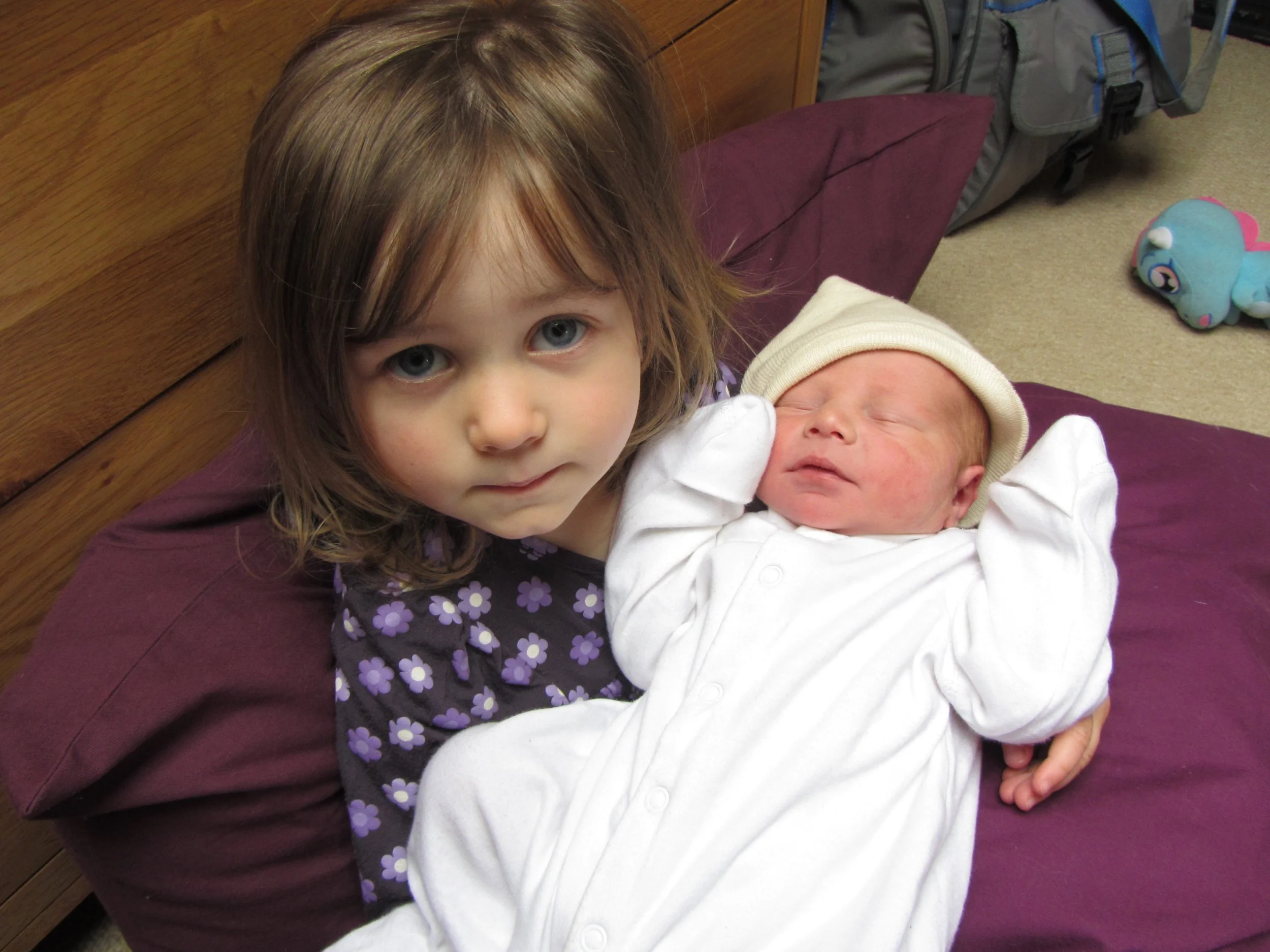 Sister earnestly holding baby brother