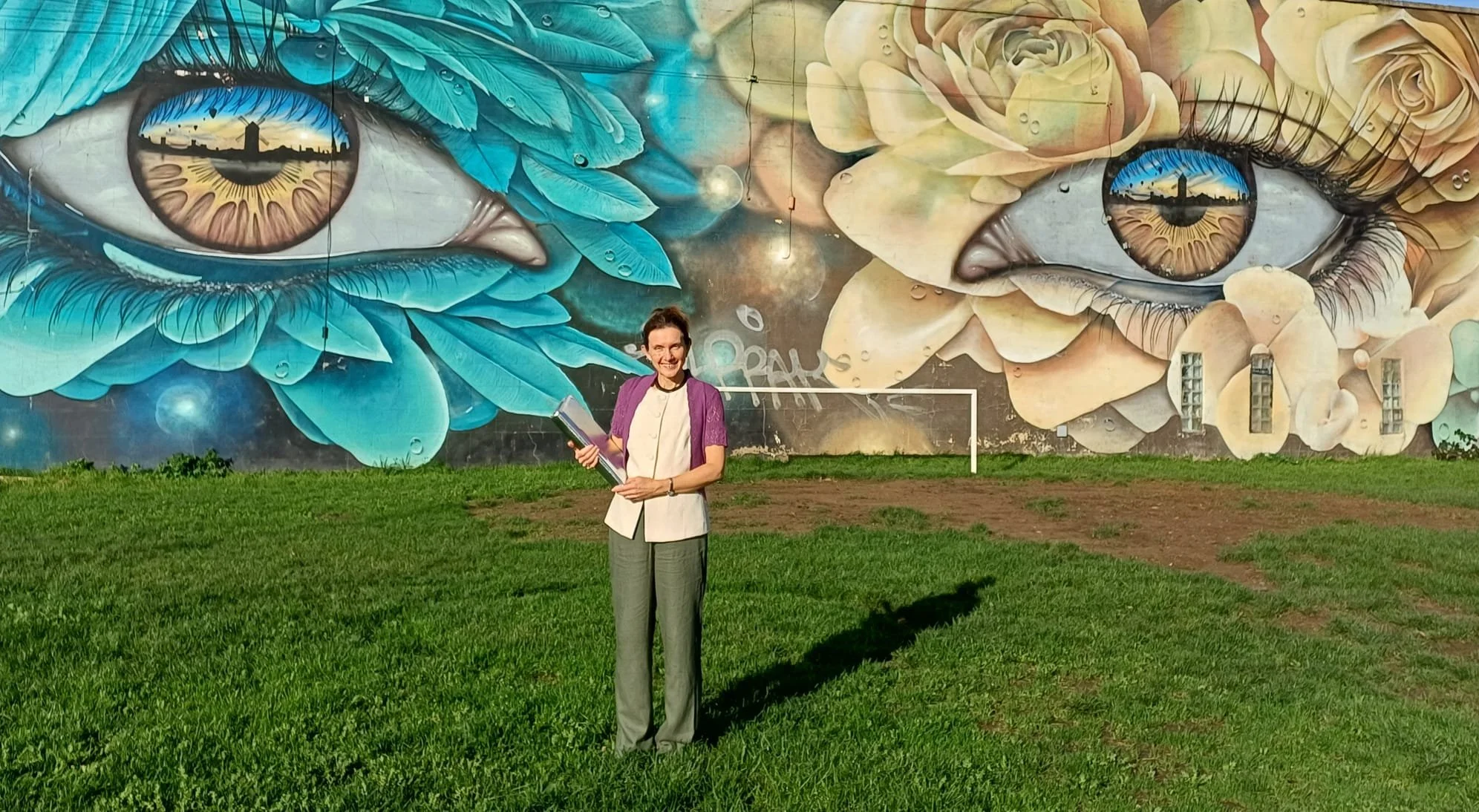 Rachel in front of a mural of eyes in Bristol