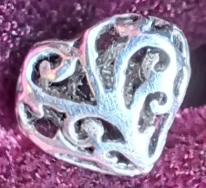 Silver celtic heart earring on purple velvet