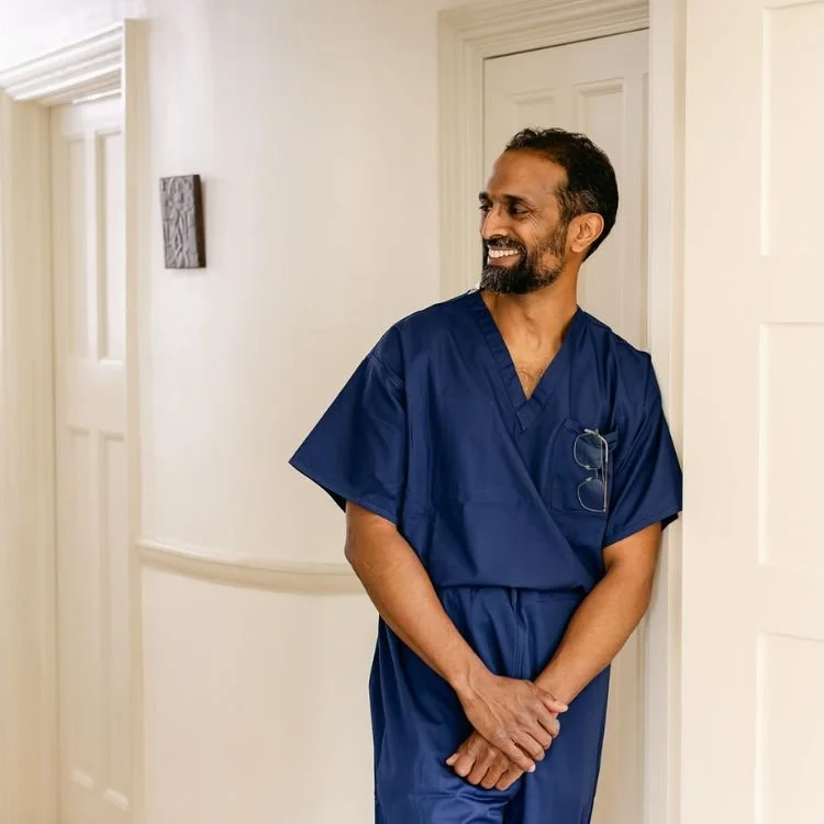 Mr Ahilan Kailaya-Vasan, private neurosurgeon in london in scrubs