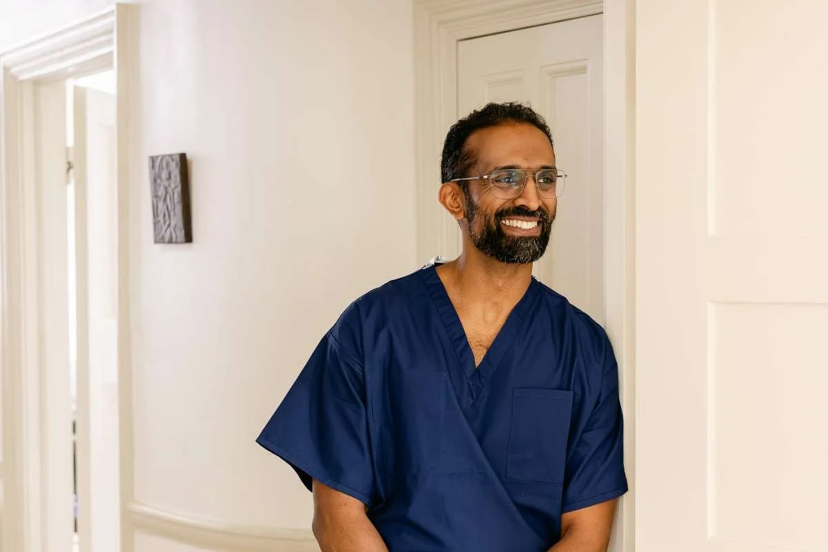 Mr Ahilan Kailaya-Vasan, private neurosurgeon and neurovascular surgeon, headshot in scrubs