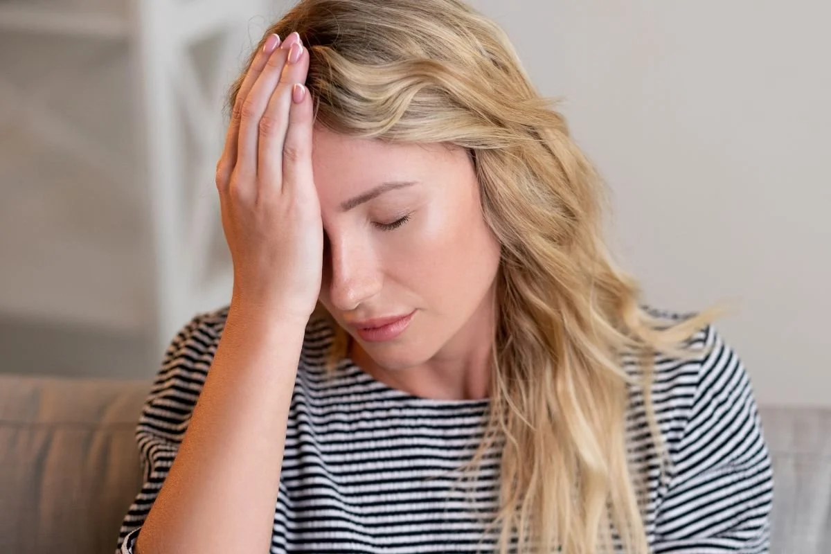 Woman touching head due to dehydration headache