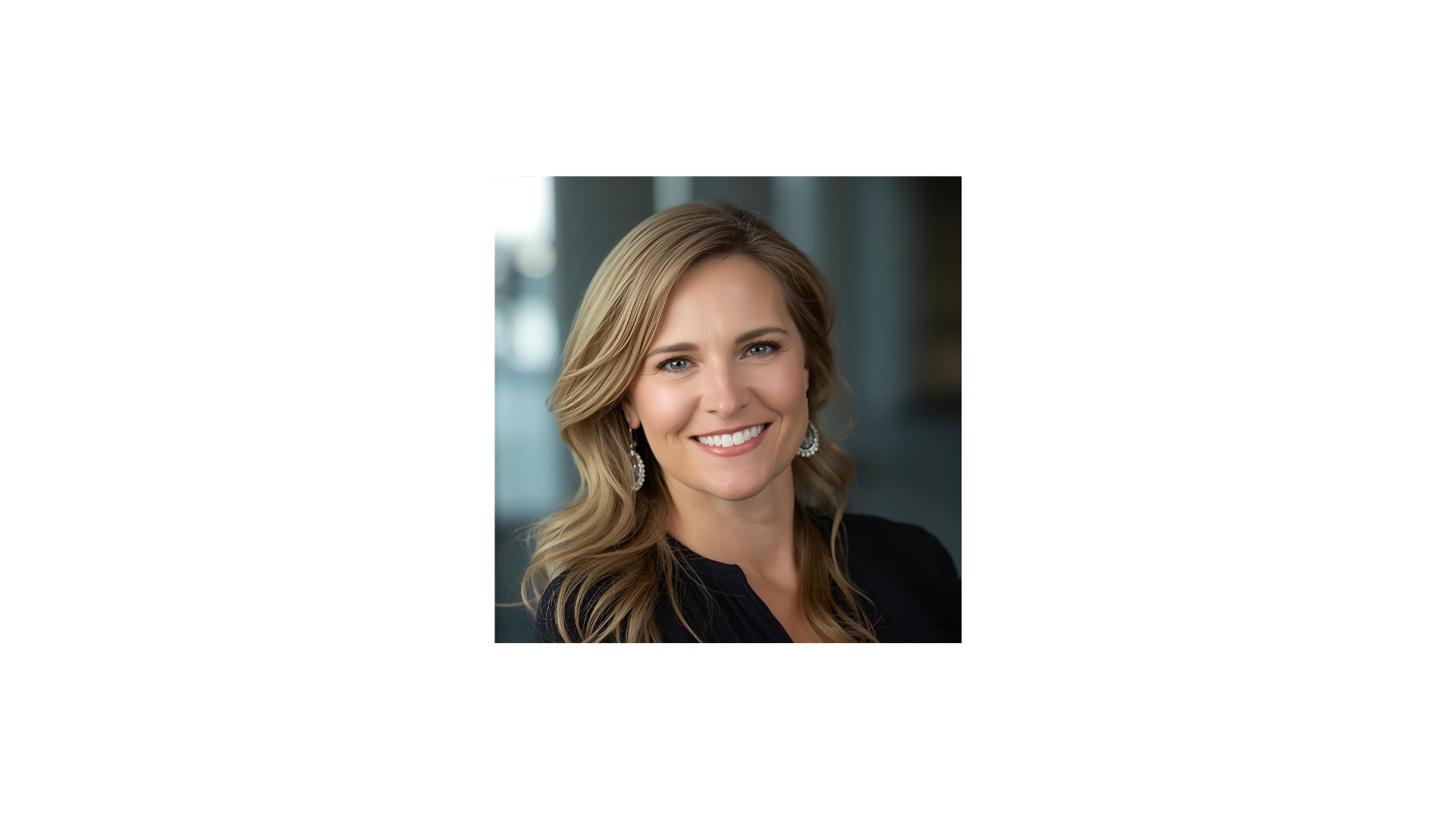 A woman with blonde hair, wearing earrings and a black top, smiling in a professional setting.