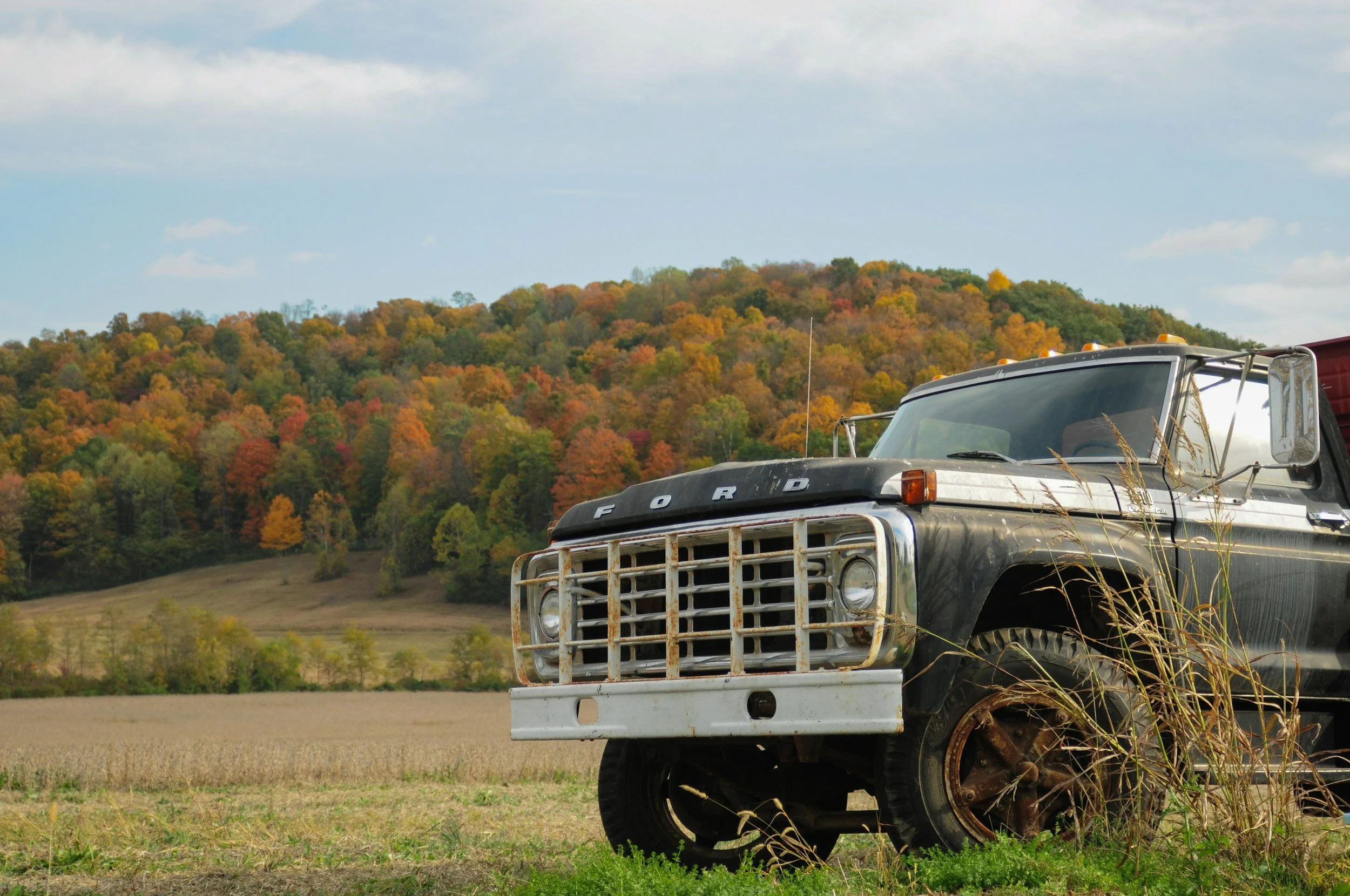 Dark grey older ford pick up truck in a field near London, Ontario on a fall day