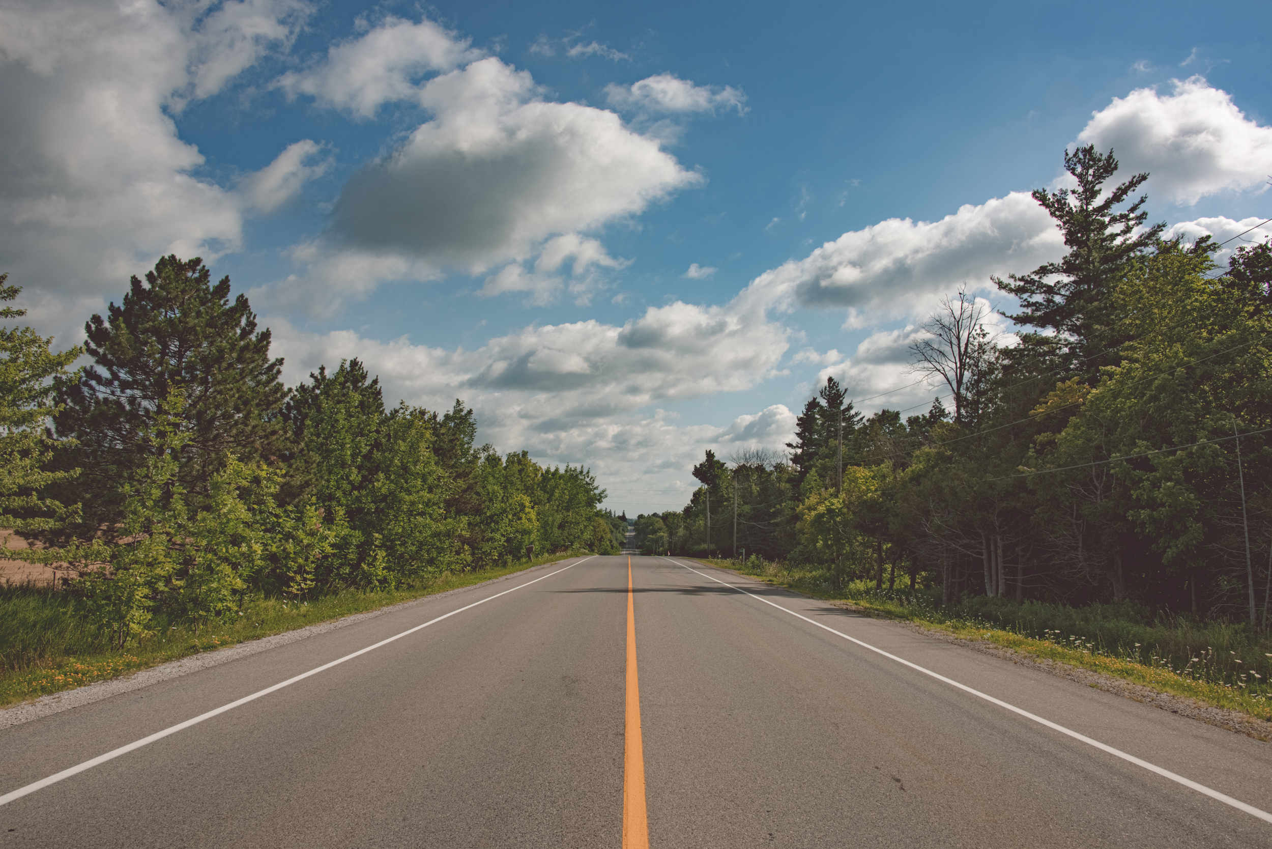 Country road near London Ontario with clouds and blue skies