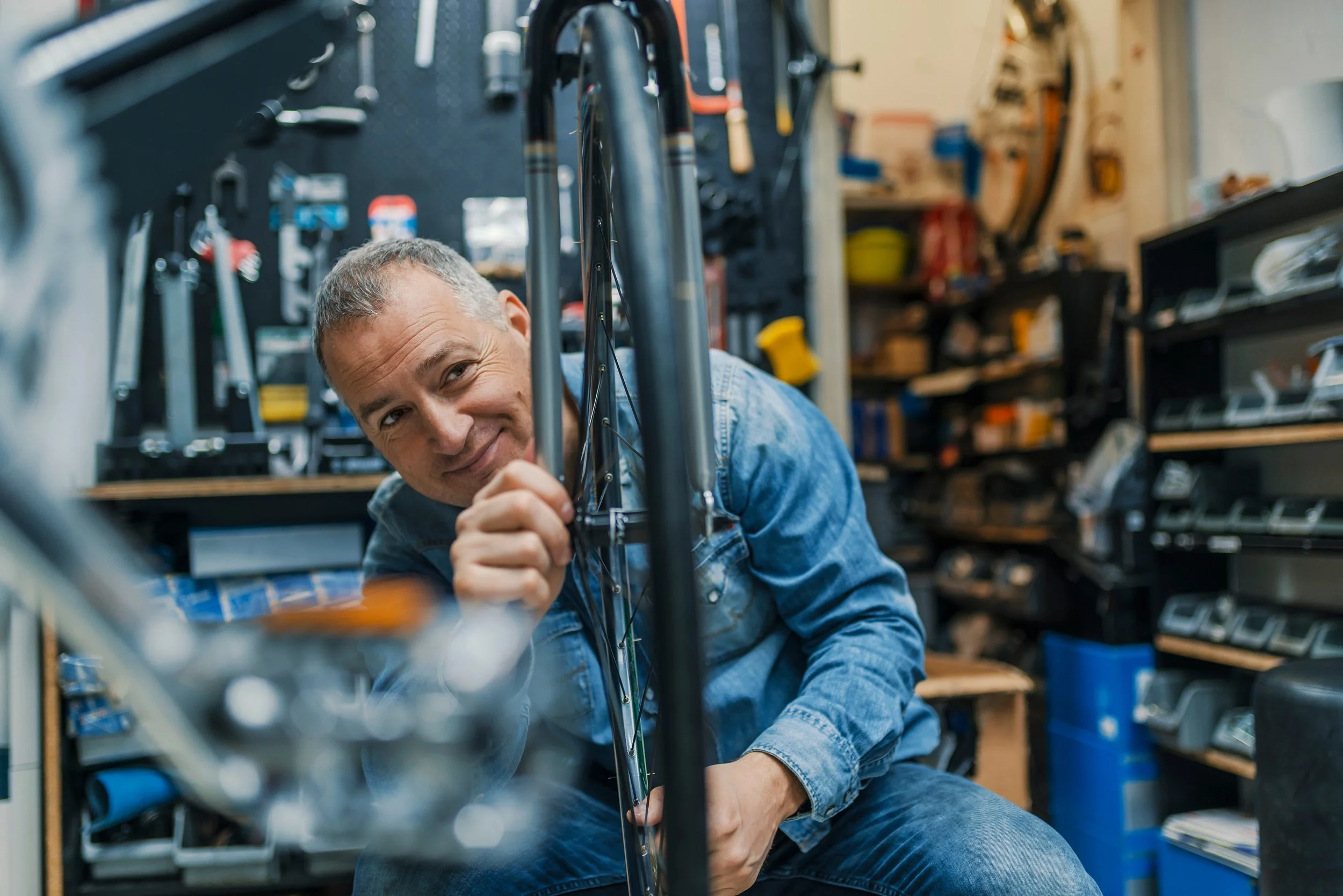 older man at his business fixing a bike