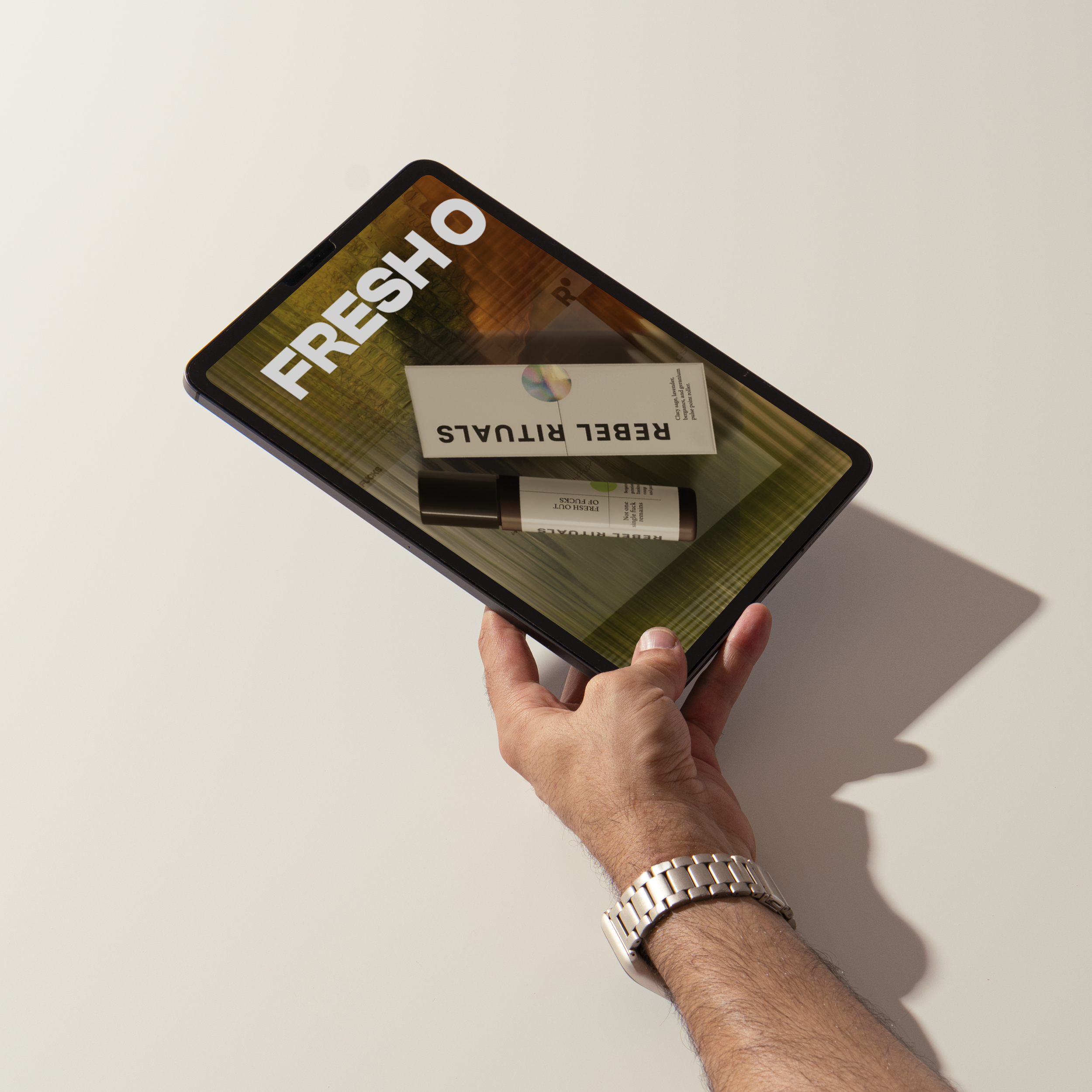 A person's hand holding a tablet displaying a refresh cycle product on the screen, with a white background.