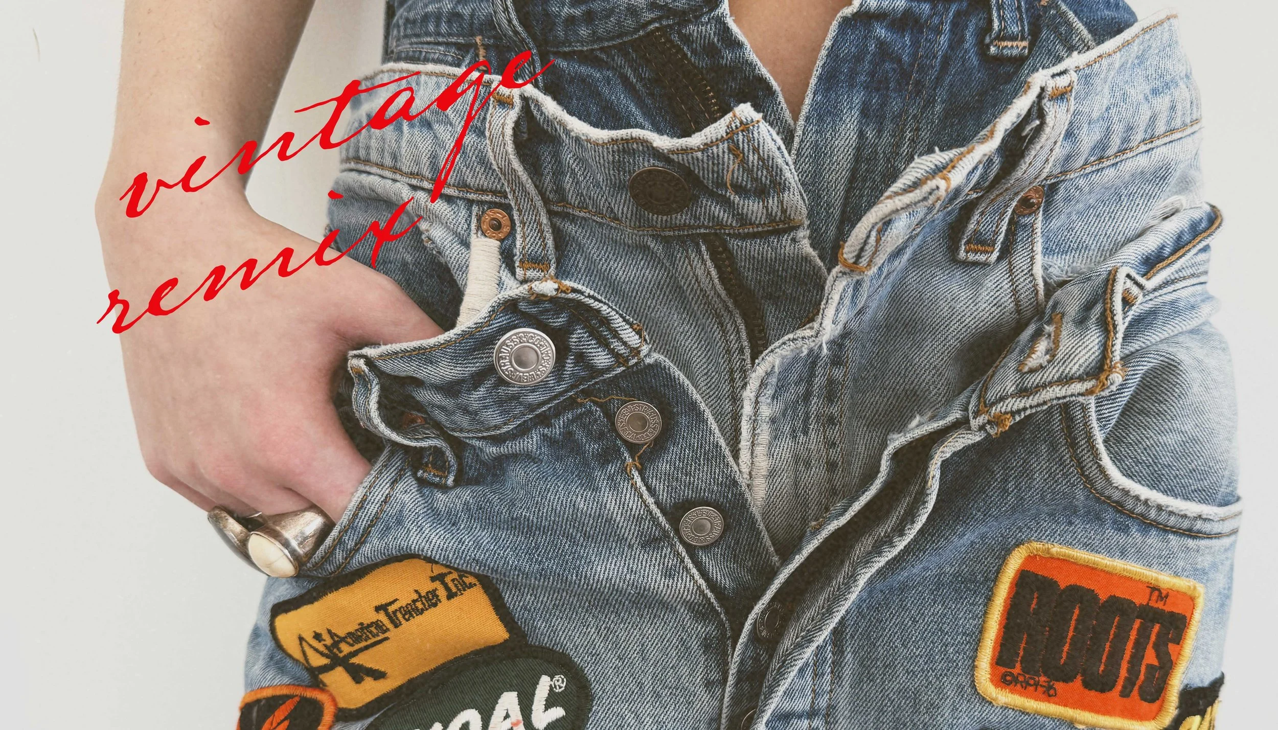 Close-up of a person wearing a distressed denim vest with patches, with their left hand on their hip and a ring on their finger. Red text overlay reads 'vintage remix'. Reworke vintage denim.