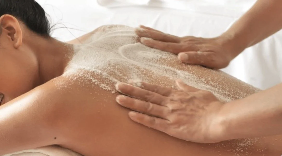 Person receiving a back massage with white powder on their back
