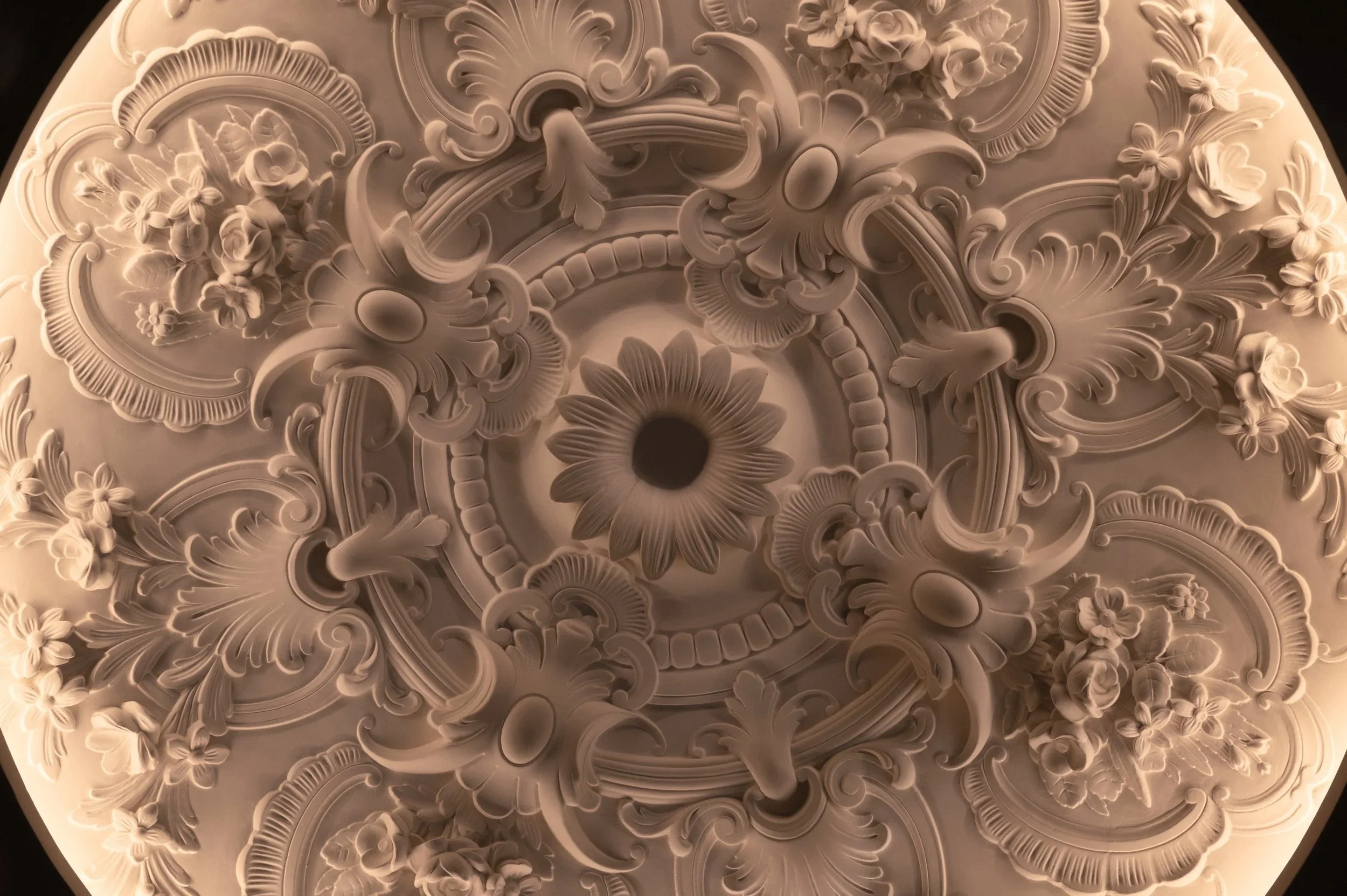 Costantini Watches Brand Identity by Define London - Watches & Jewellery, Ornate ceiling medallion with intricate floral and scroll designs, featuring a central sunflower motif surrounded by detailed flower arrangements.