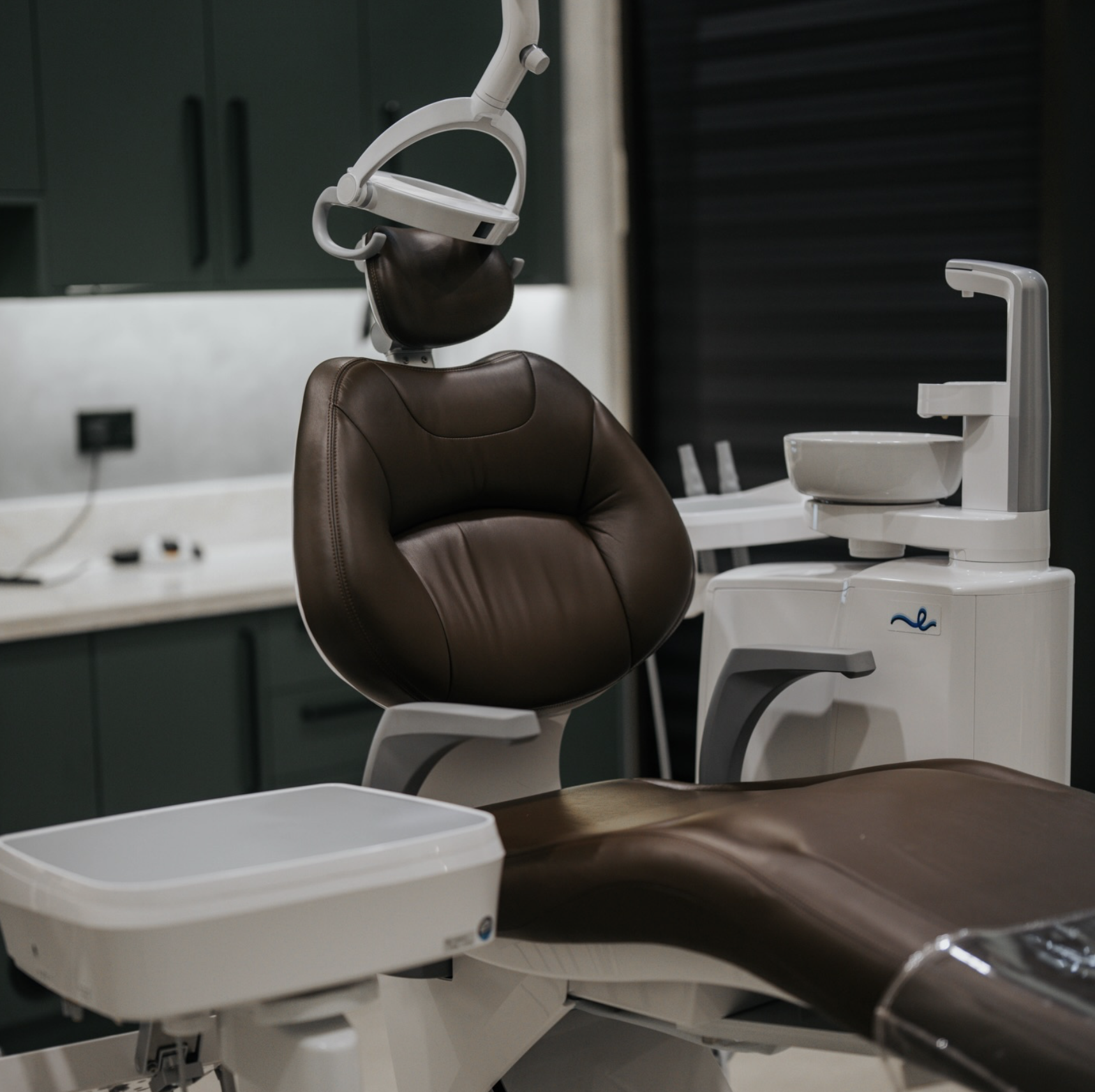Arte Dental brand identity by Define London - Empty dental chair with brown cushion in a dental clinic room.