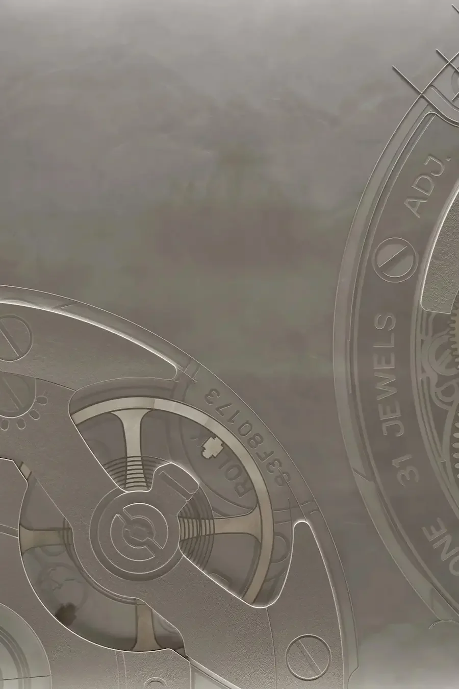 Close-up of the intricate details and engravings on a transparent mechanical watch movement with visible gears and markings.
