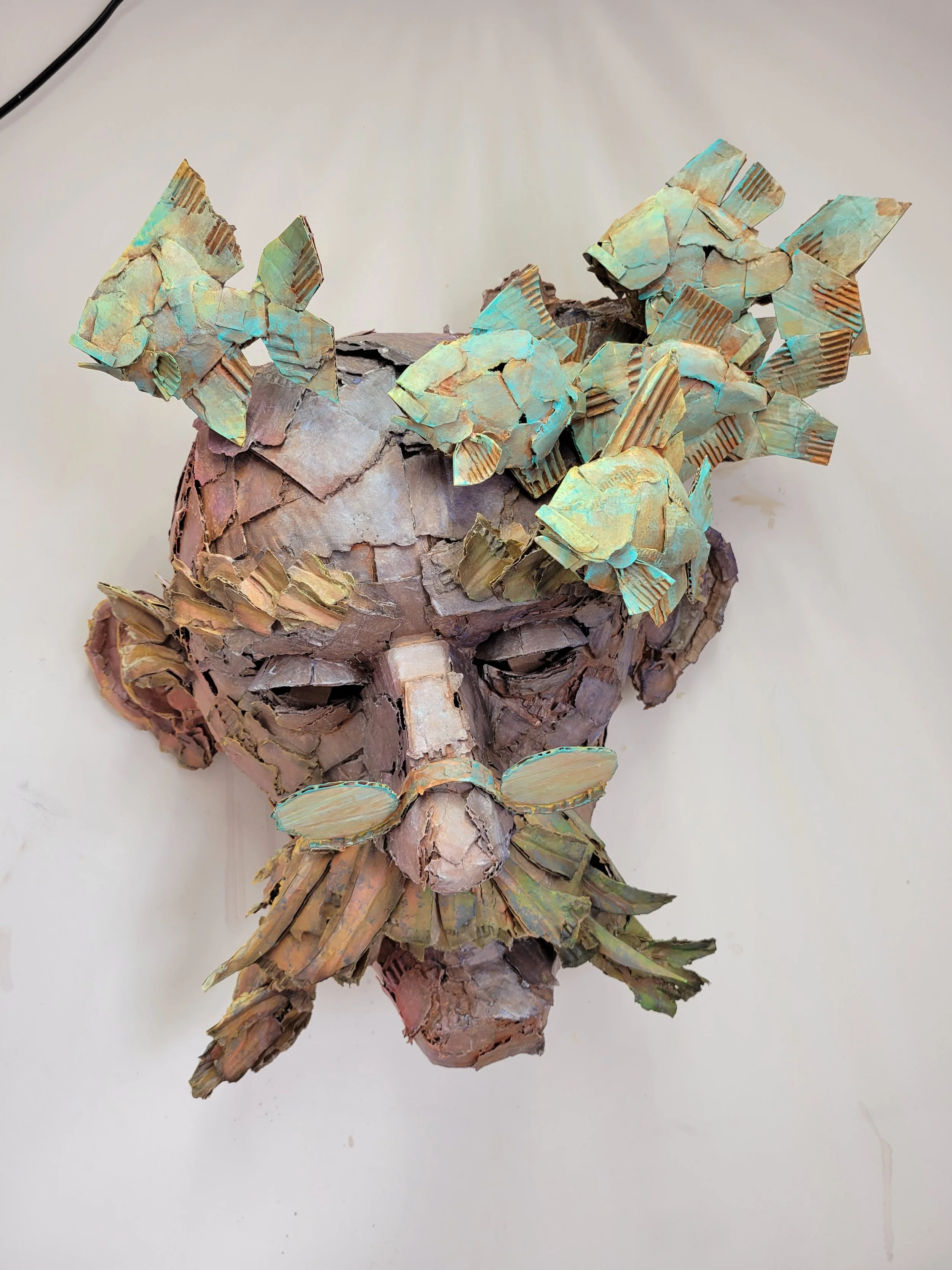 A sculpture of an old man's face made of cardboard.