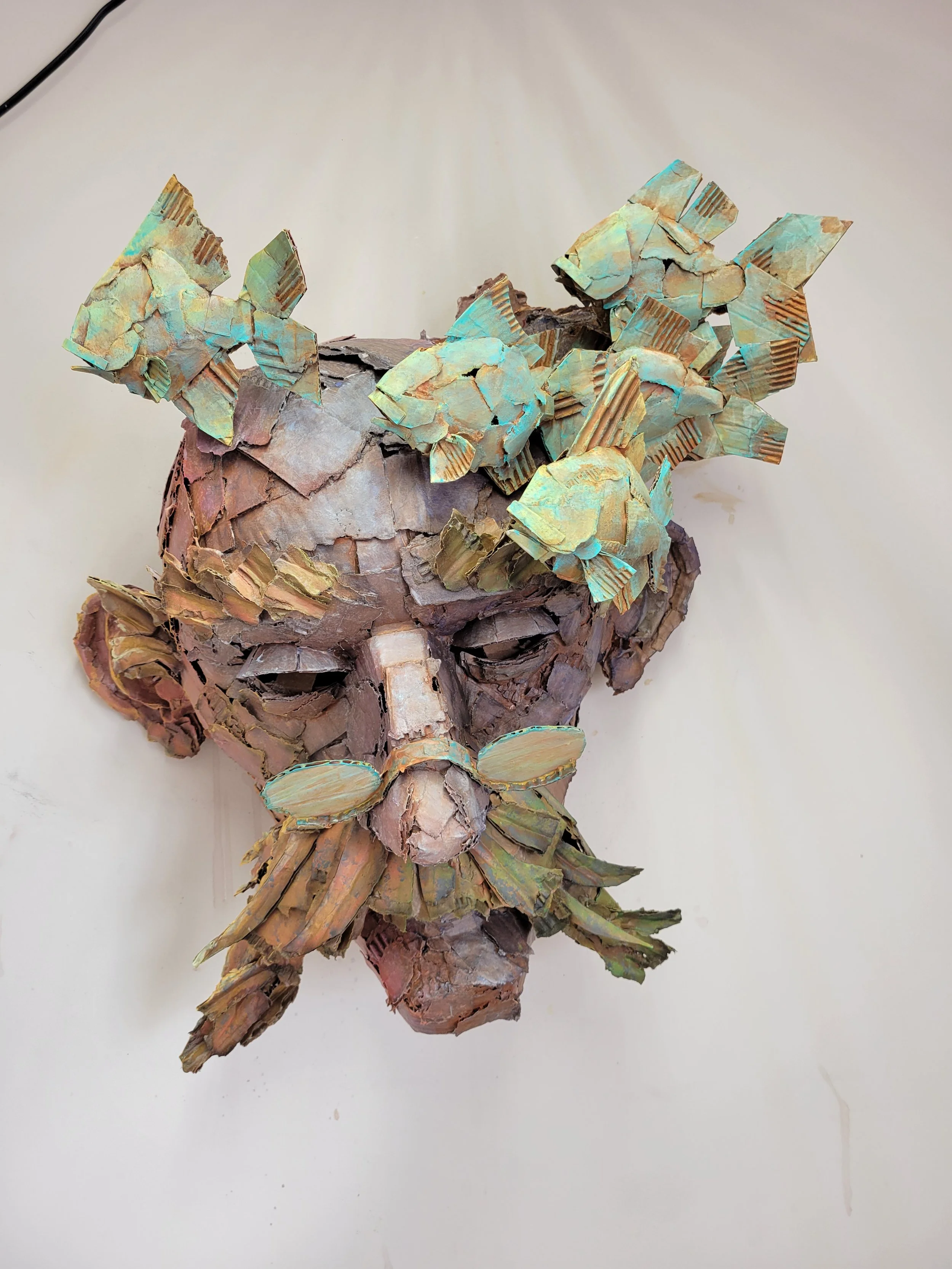 A sculpture of an old man's face made of cardboard.