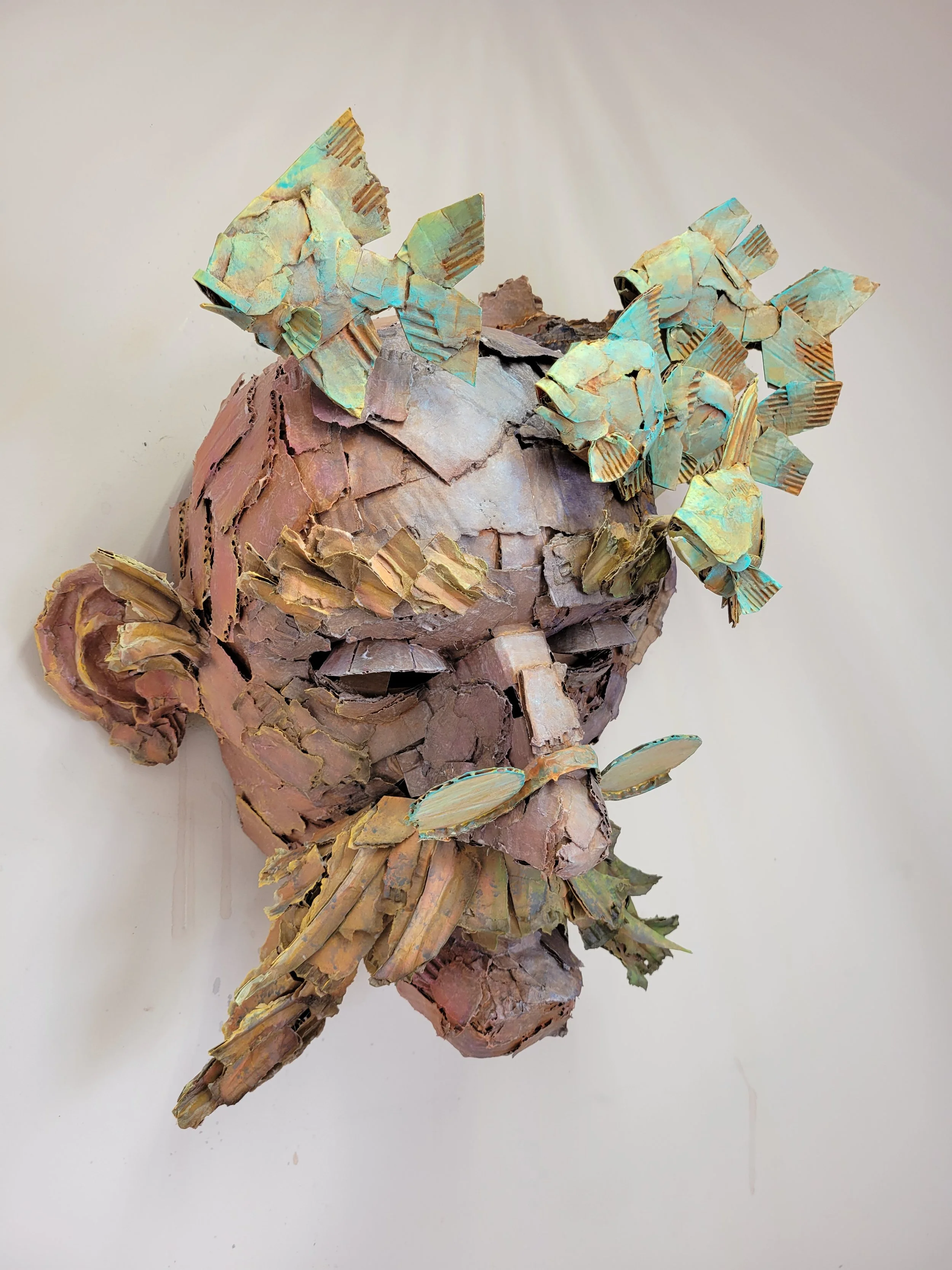 A sculpture of an old man's face made of cardboard.