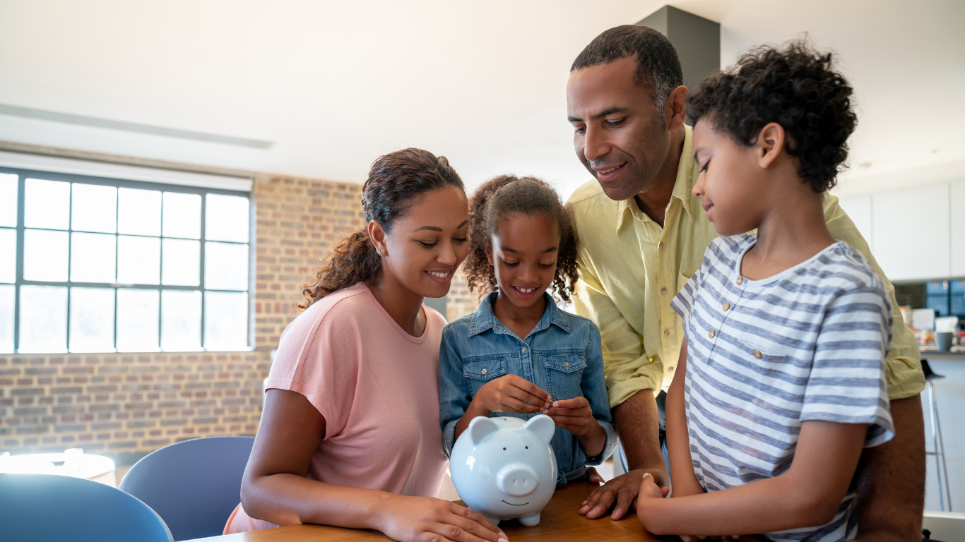 Family putting money into a piggybank to save