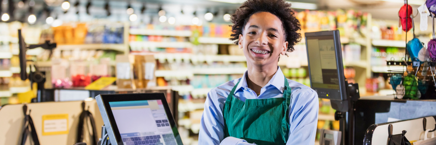 Teen boy working at a grocery store counter