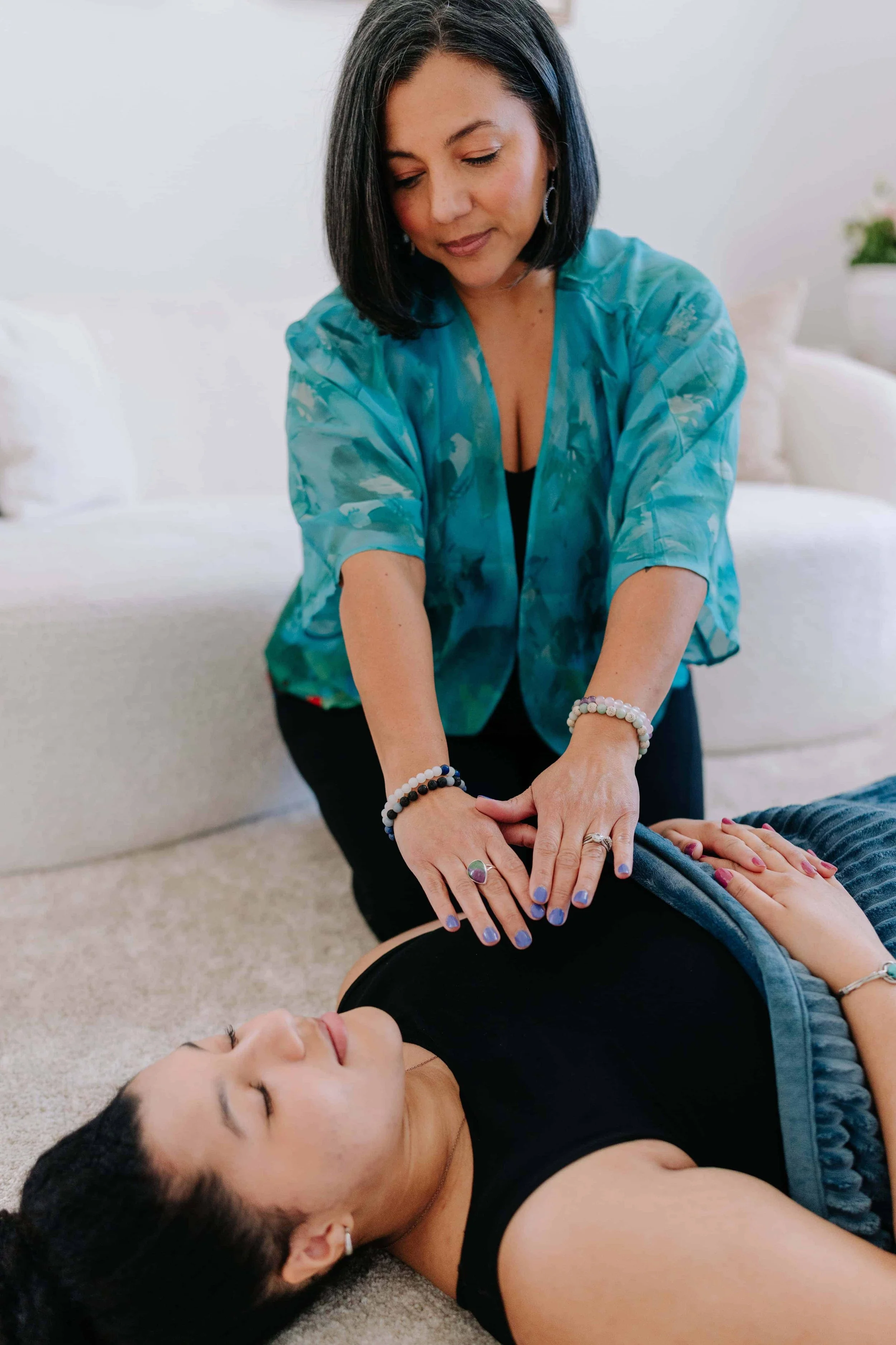 Breathwork practitioner working with client in a bright room.