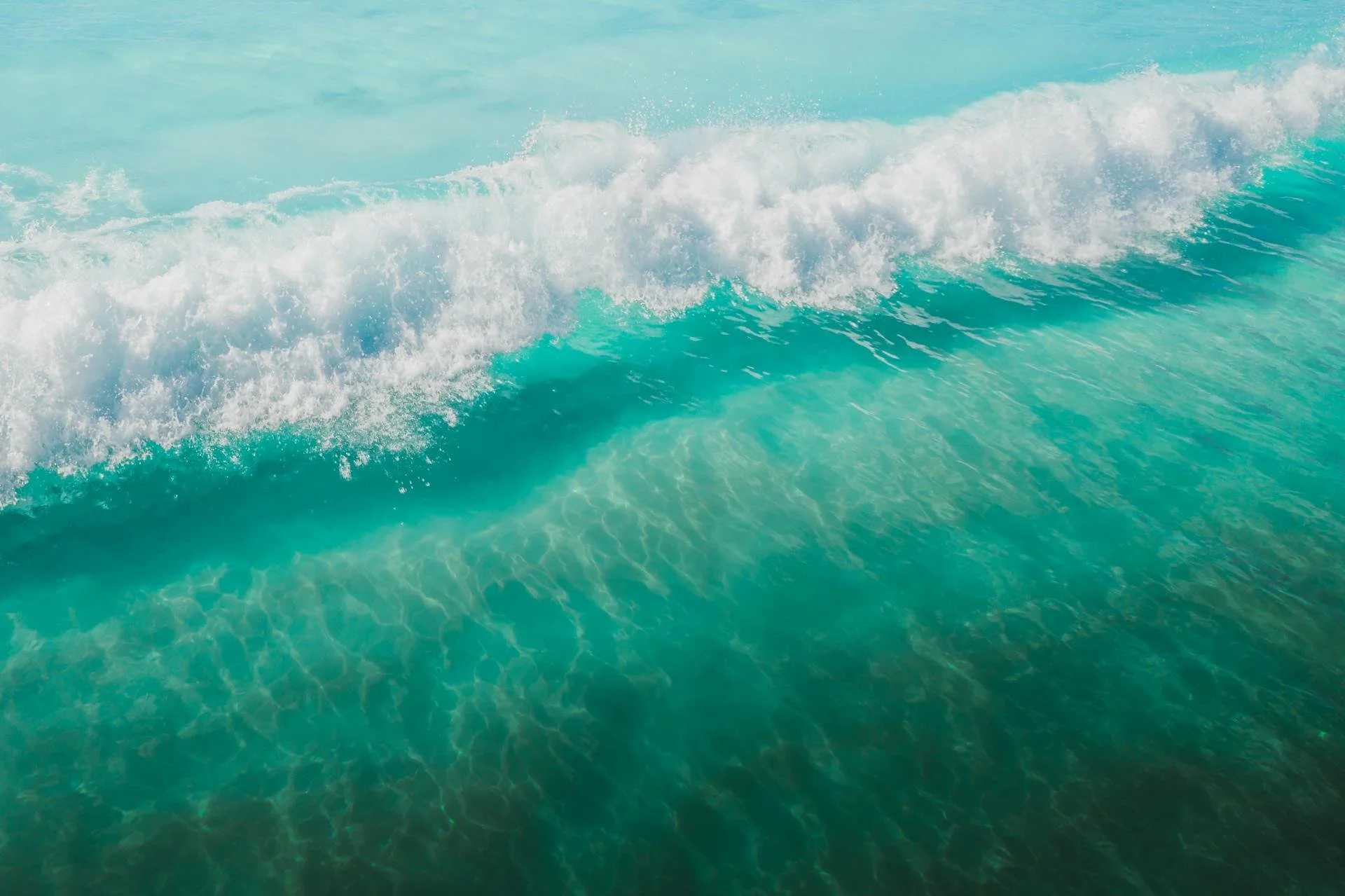 Ocean waves with white foam and clear turquoise water.