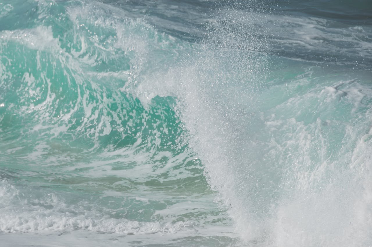 Close-up of a large ocean wave crashing with white foam and spray.