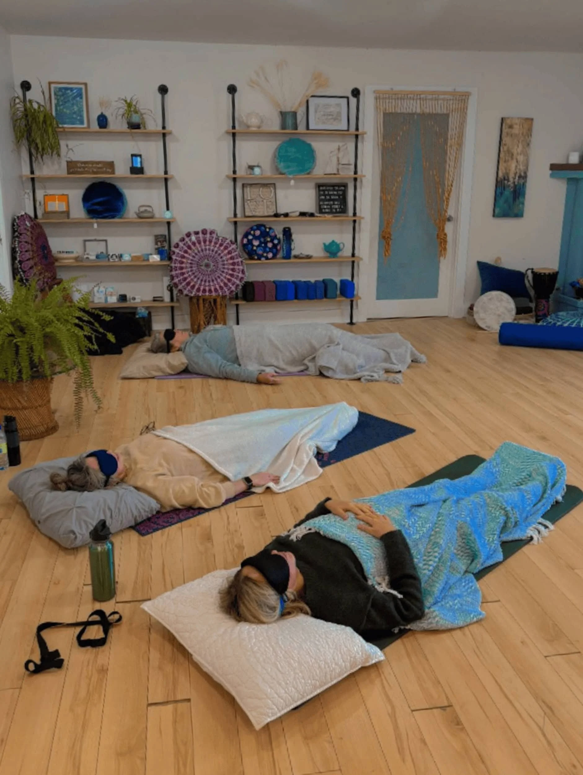 Group of people laying relaxed on the floor during breathwork session.
