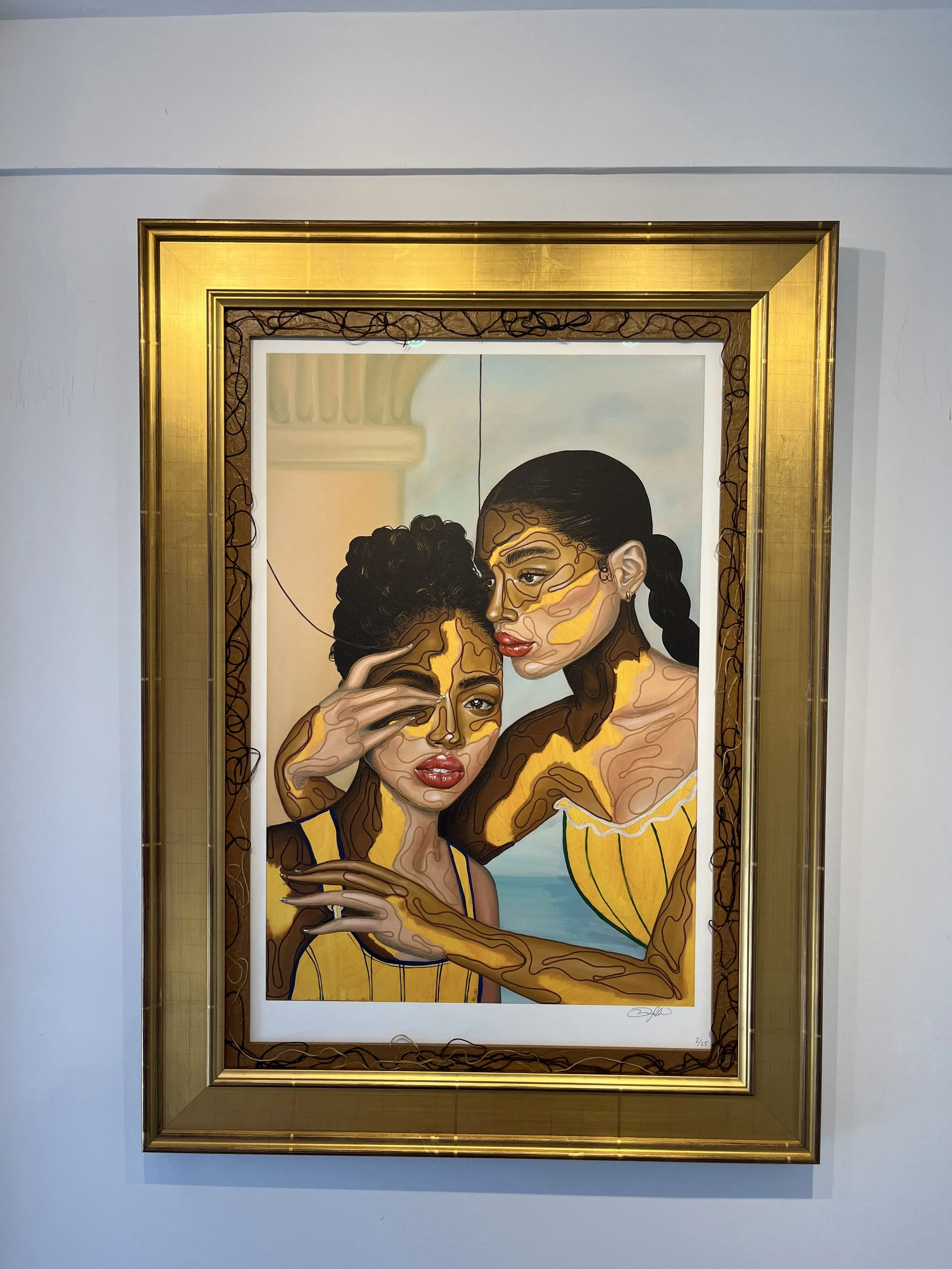 A colorful painting of two women with dark hair and brown skin, wearing yellow clothing, close together with one woman touching her forehead to the other's. The background includes stylized architectural elements and a blue sky.