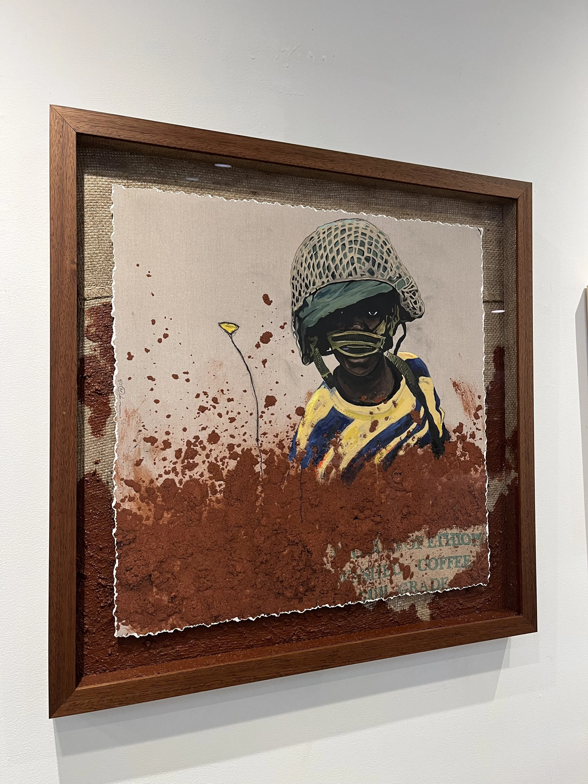Mixed media artwork of a person wearing a military helmet and sunglasses, with a background splattered with red paint and torn paper edges.