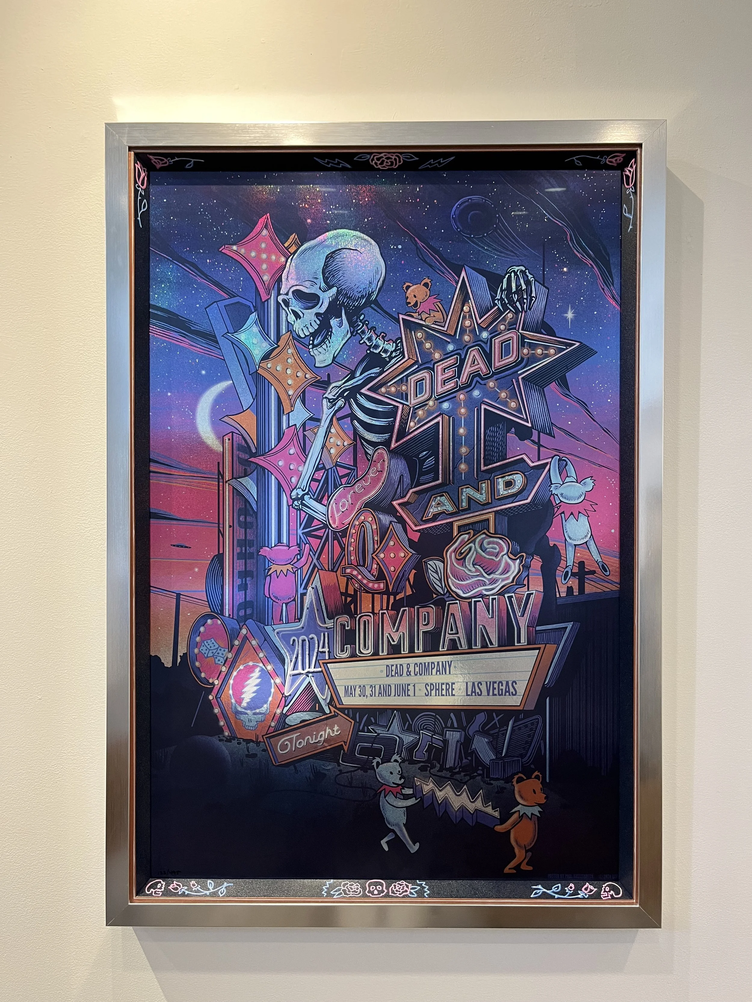 Colorful poster for Dead and Company concert in Las Vegas featuring a skeleton with a cosmic background, cartoon animals, and neon elements.