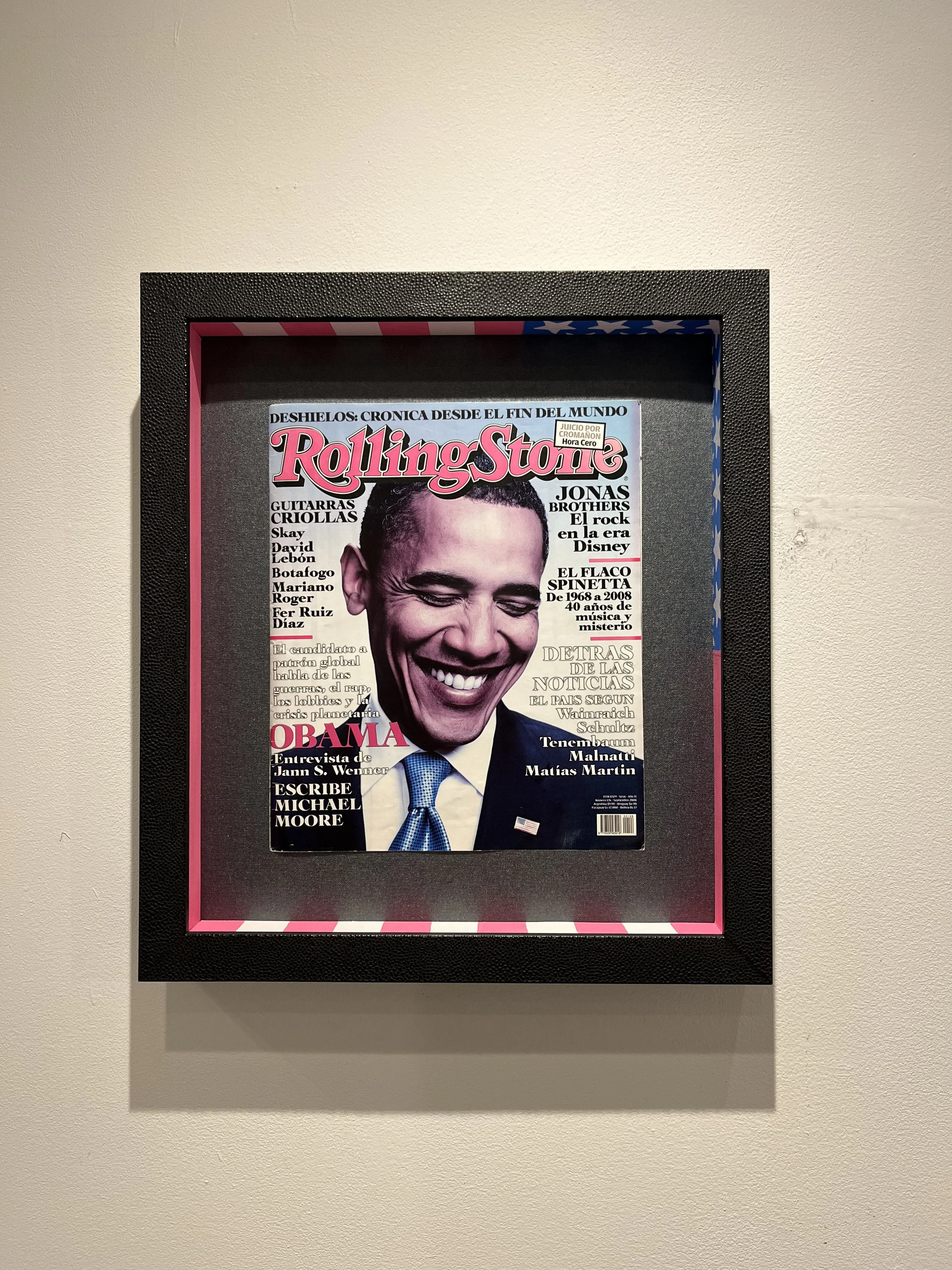Framed cover of Rolling Stone magazine featuring a smiling Barack Obama, with headlines and articles in Spanish.