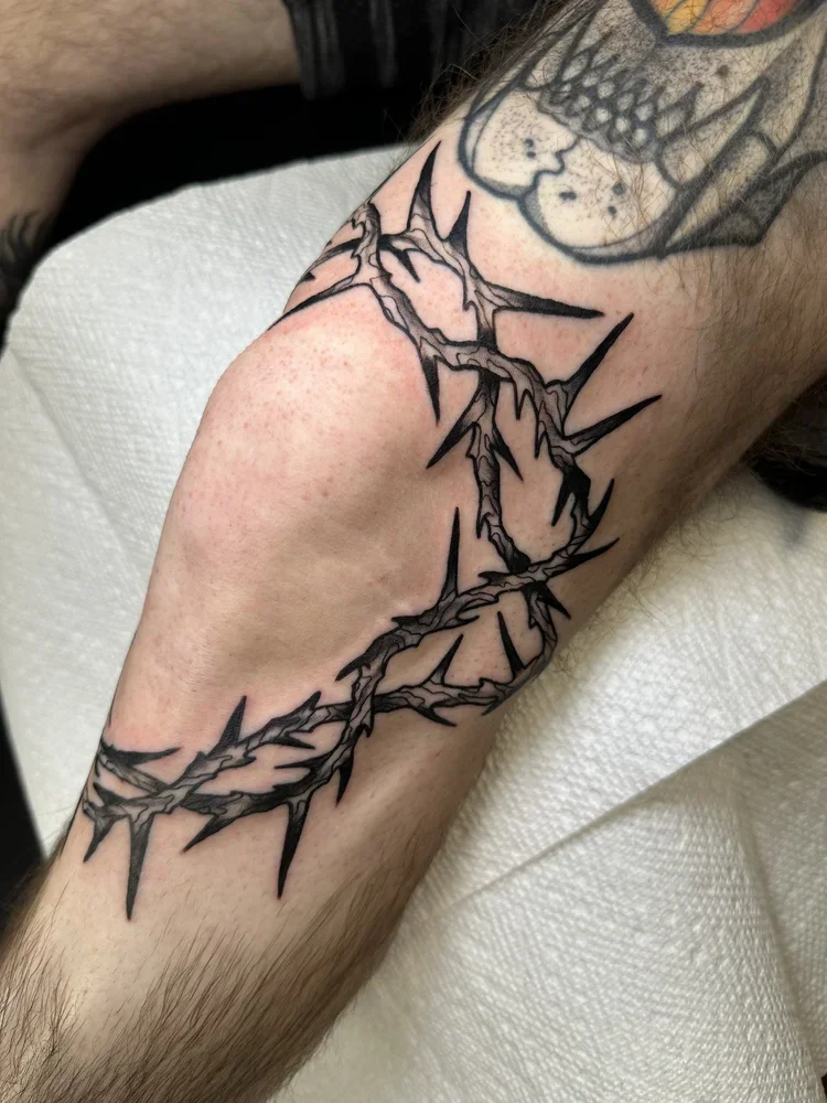 Tattoo of a jagged lightning bolt on a person's forearm.