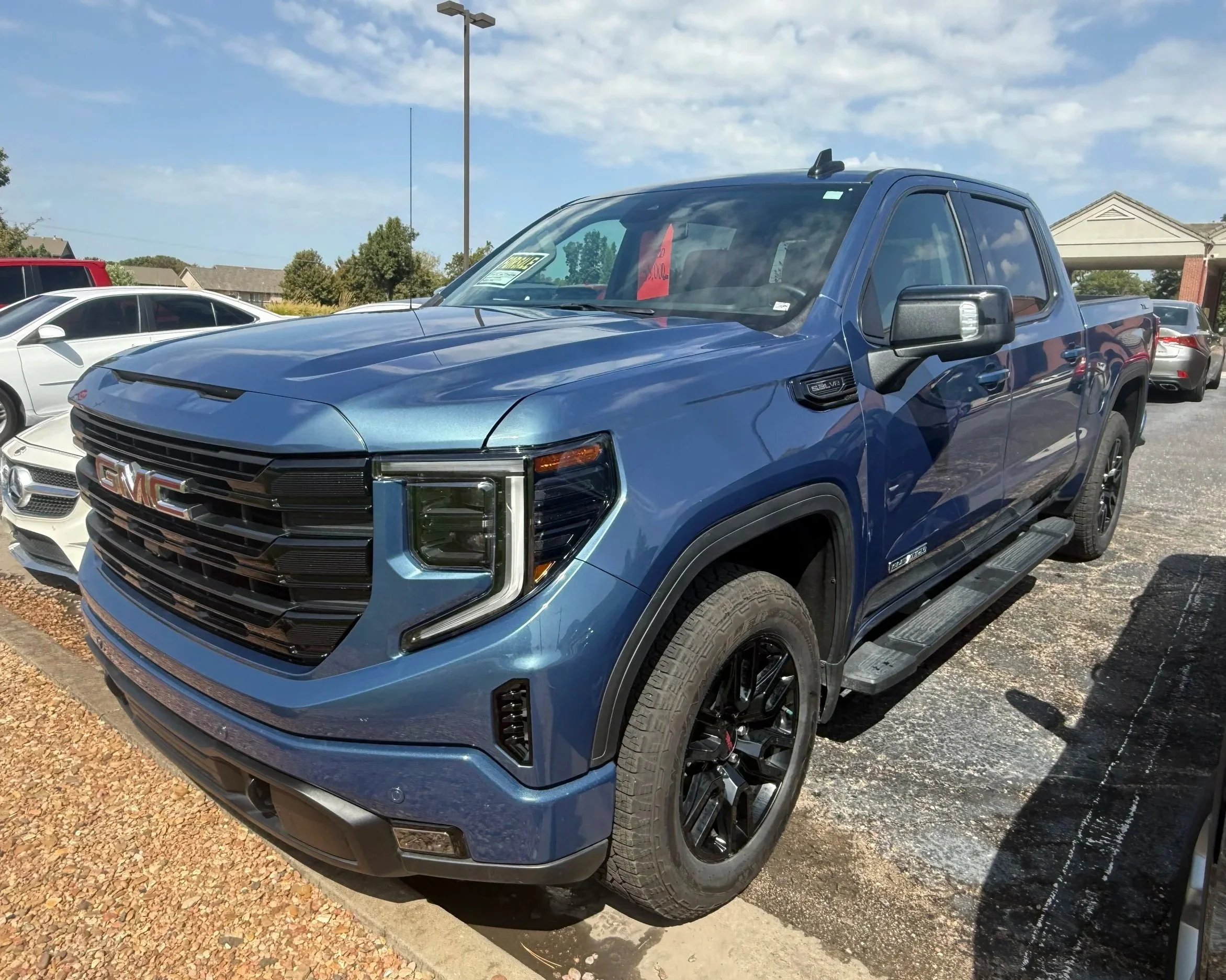 A blue 2026 GMC Sierra sits in the Quantum Credit Union parking lot.