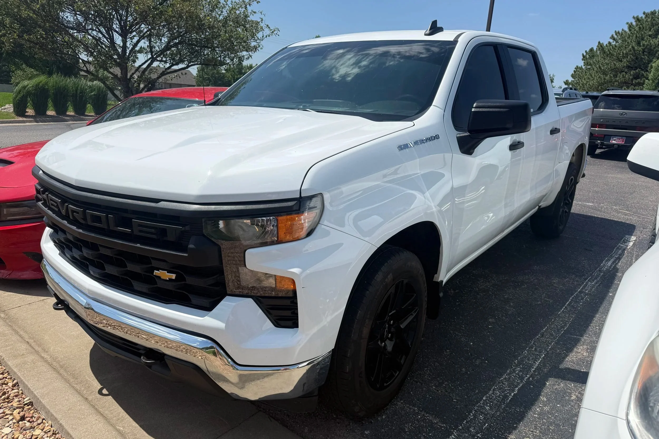 A white 2024 Chevrolet Silverado sits in the Quantum Credit Union parking lot