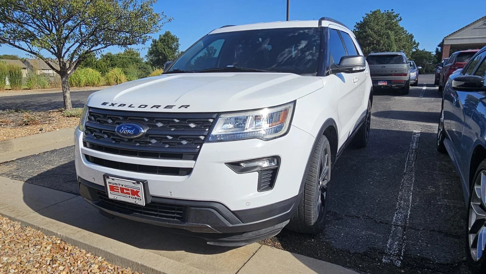 A white 2018 Ford Explorer sits in the Quantum Credit Union parking lot.