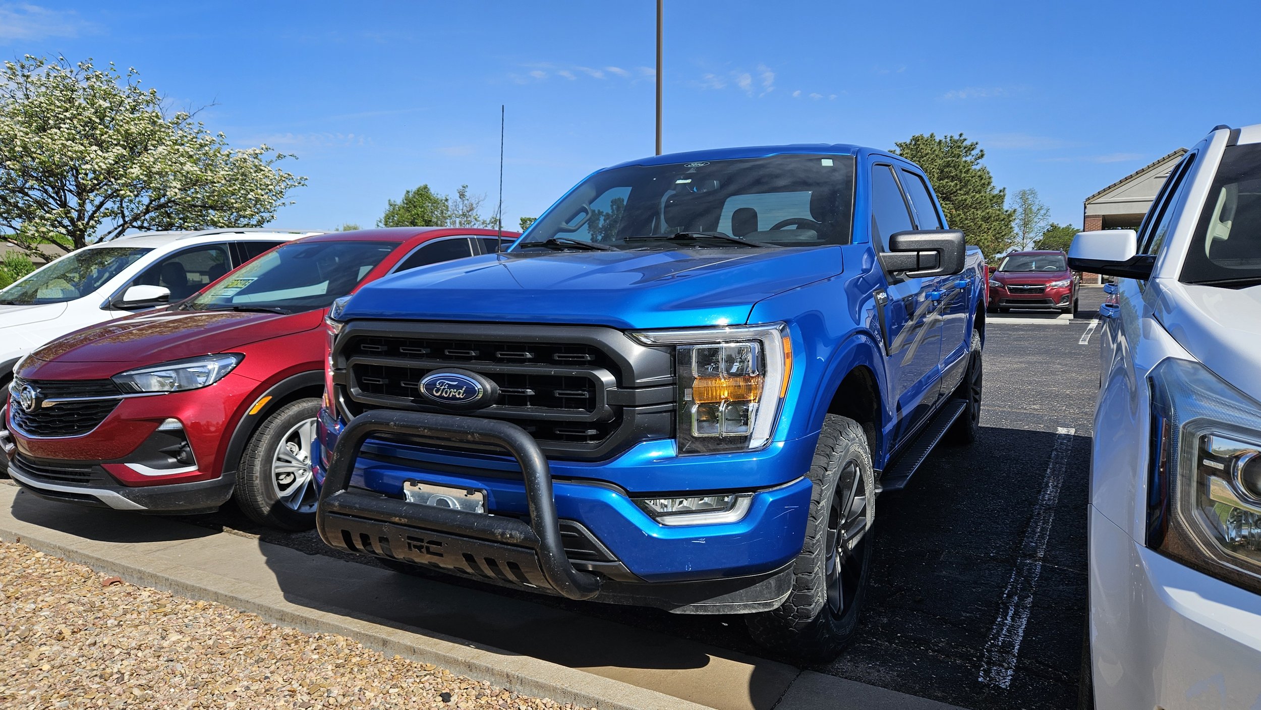 A blue 2021 Ford F-150 sits in the Quantum Credit Union parking lot.