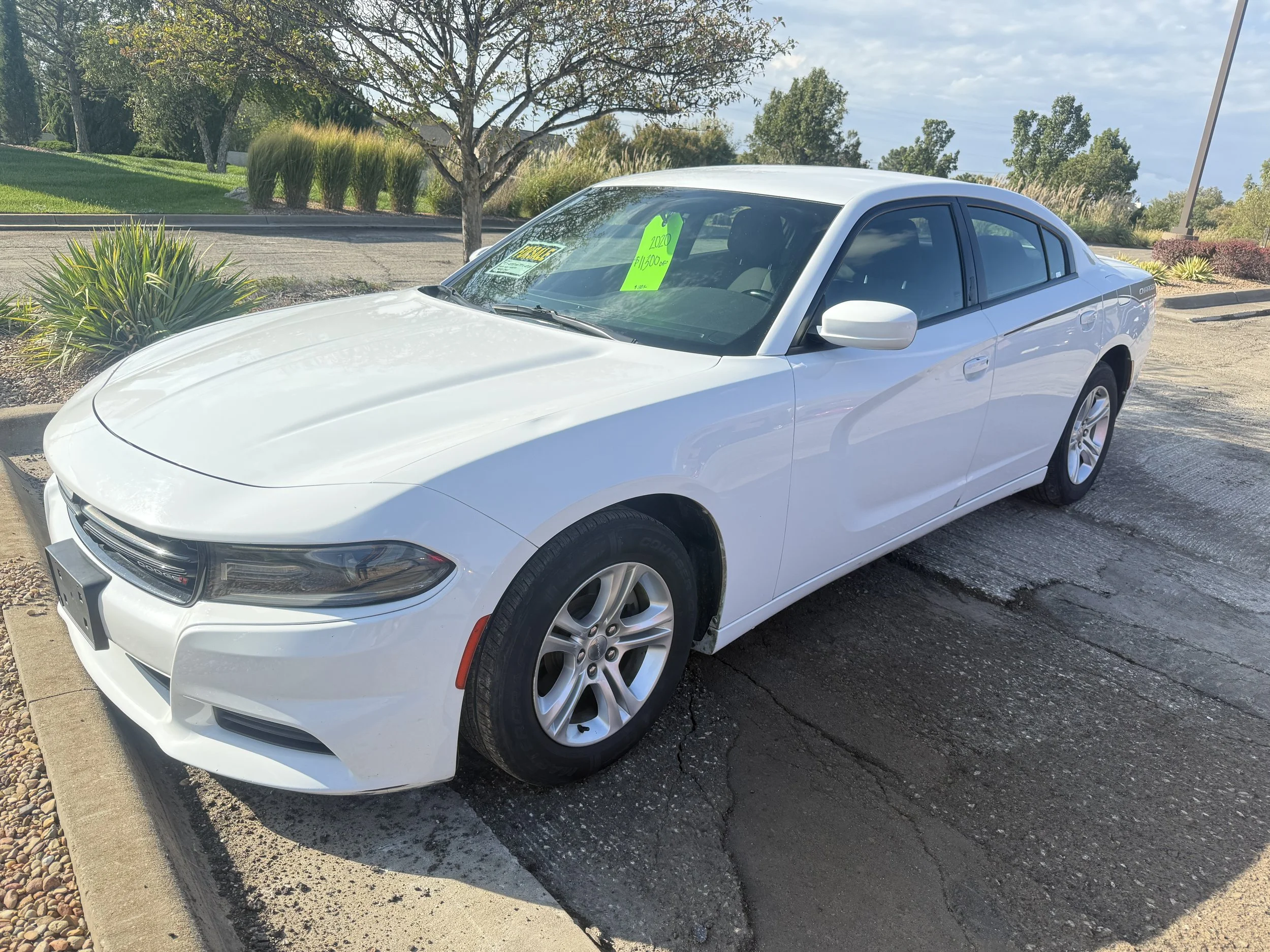 A white 2020 Dodge Charger sits in the Quantum Credit Union parking lot.