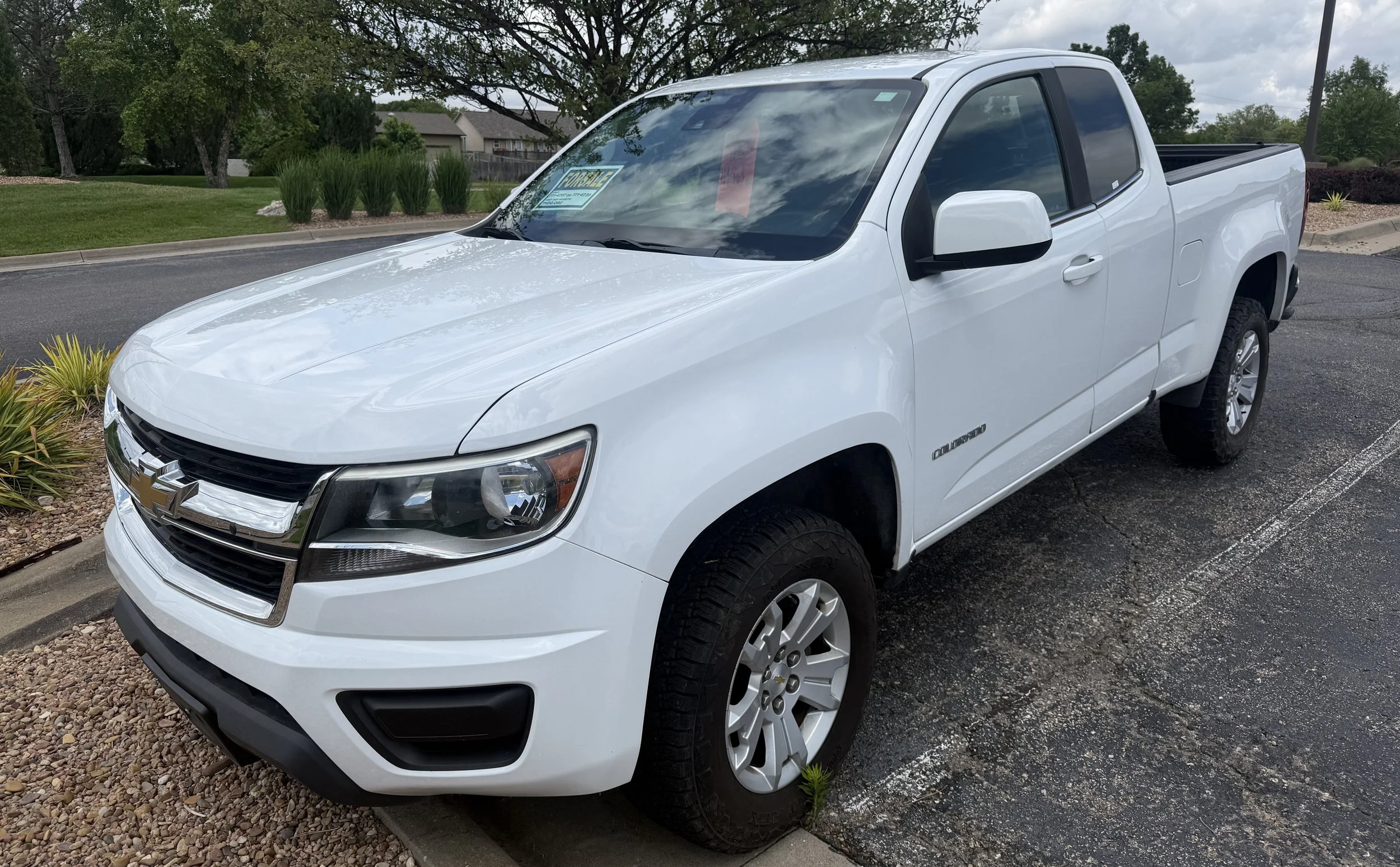 A white 2020 Chevrolet Colorado sits in the Quantum Credit Union parking lot.
