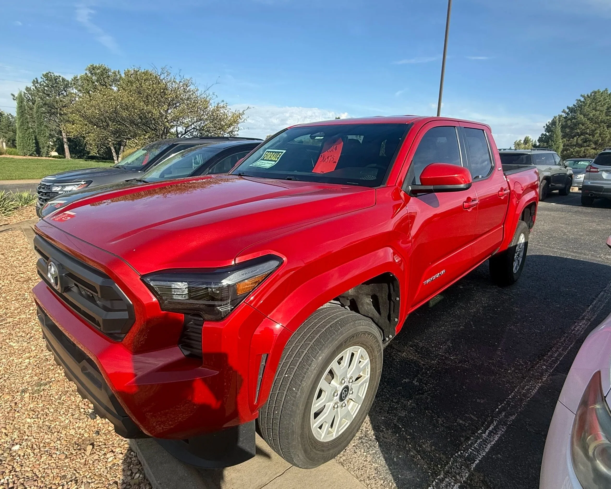 A  red 2024 Toyota Tacoma sits in the Quantum Credit Union parking lot.