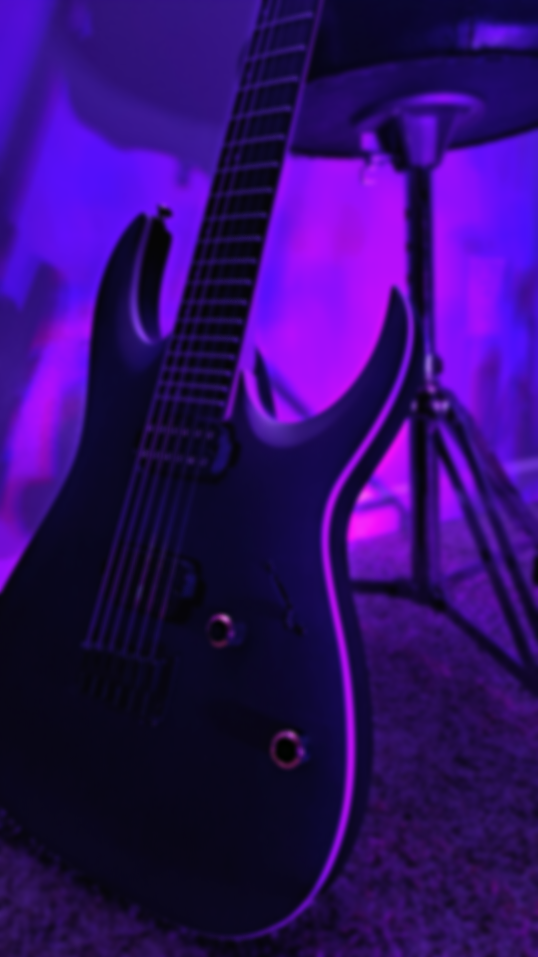 Close-up of an electric guitar illuminated with purple lighting, with a tripod stand visible in the background.