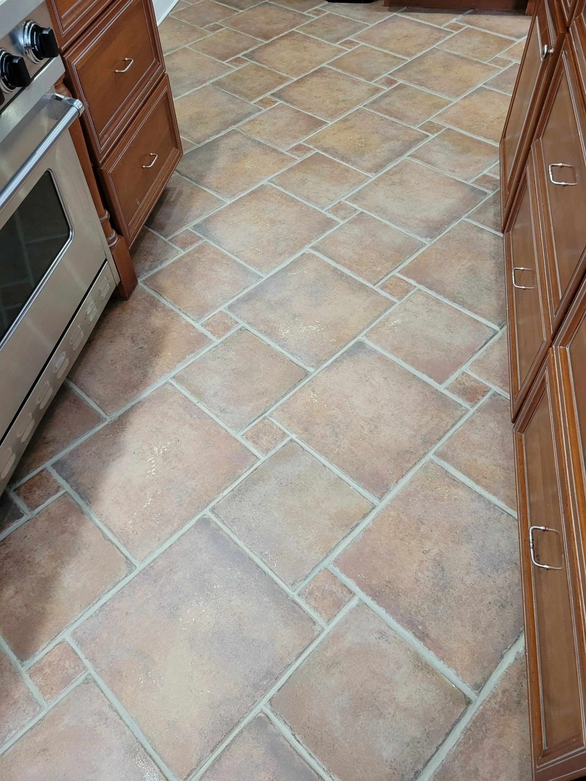 after - Kitchen floor with large, rectangular, tan ceramic tiles. Cleaned regrouted and restored