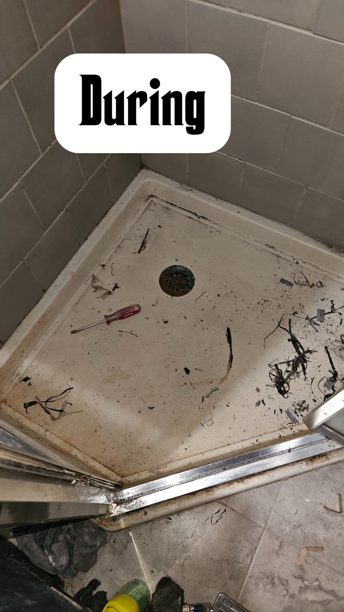 Dirty shower stall with debris, wires, and a screwdriver, during renovation or cleaning.